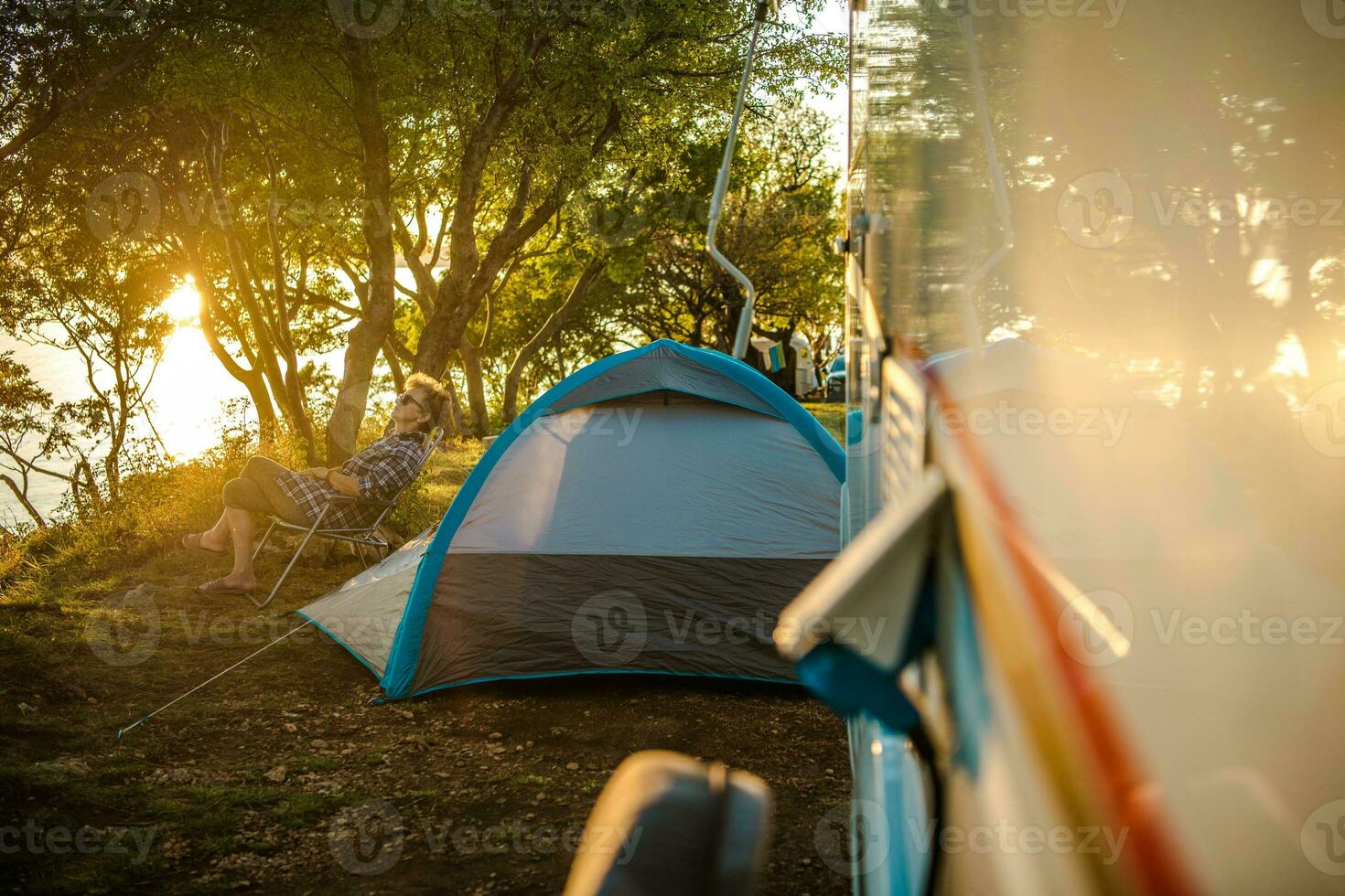 Female Traveler Relaxing Outside Of Camper Van. photo