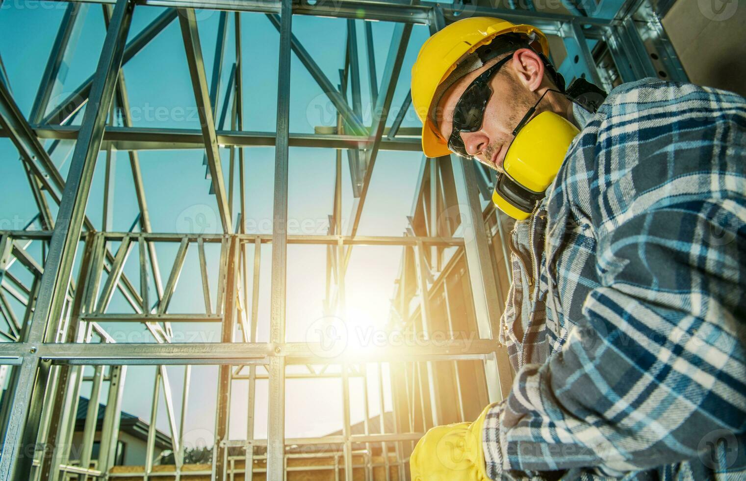 cansado construcción trabajador en frente de acero casa marco foto