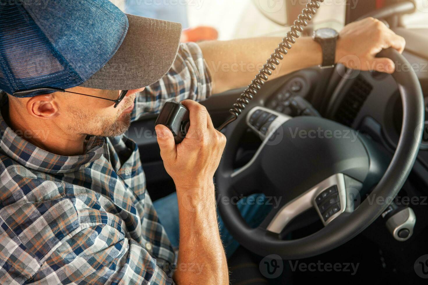 Caucasian Trucker Providing Conversation Using CB Radio Inside His Truck photo