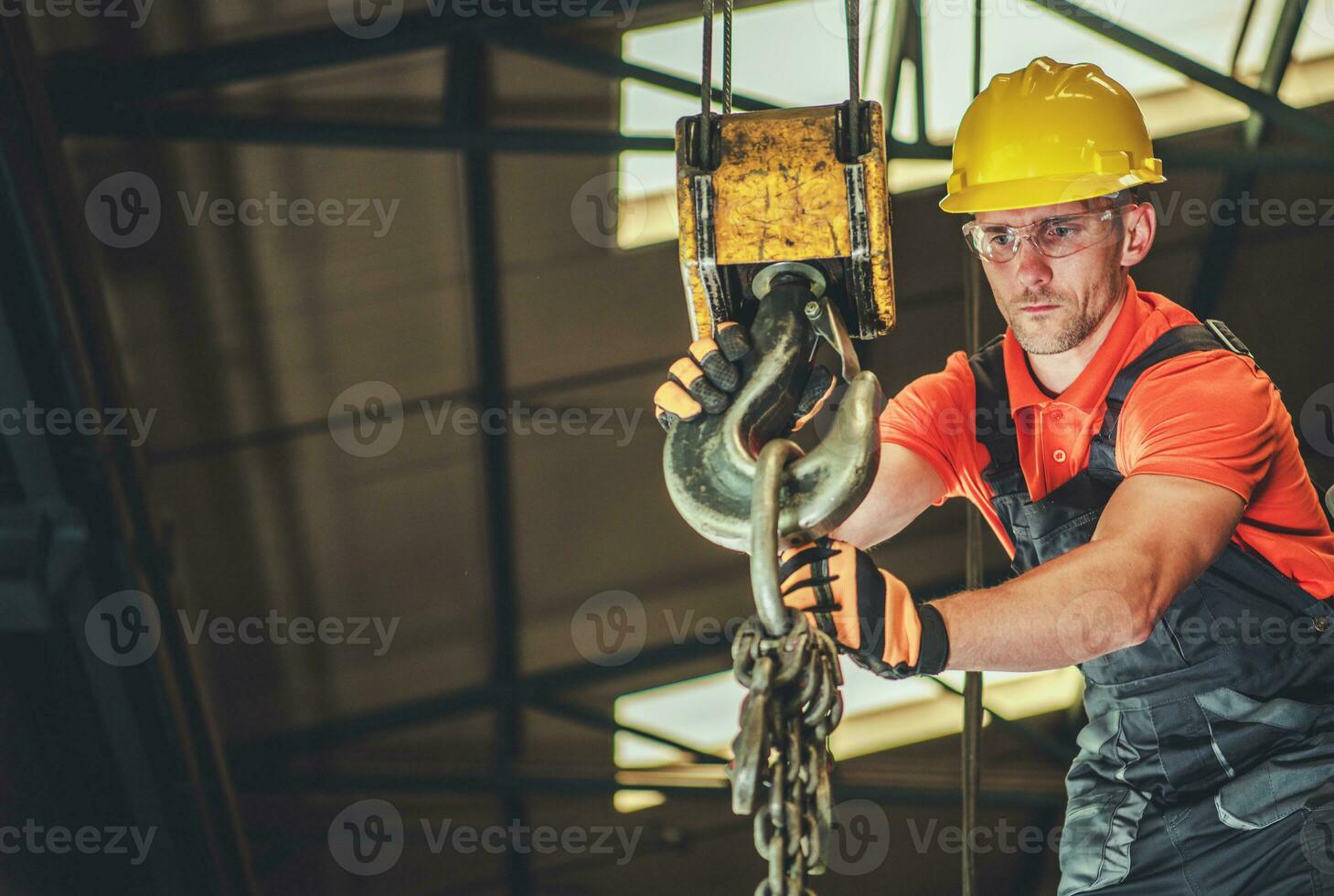 Construction Worker Operating an Overhead Crane at Building Site photo