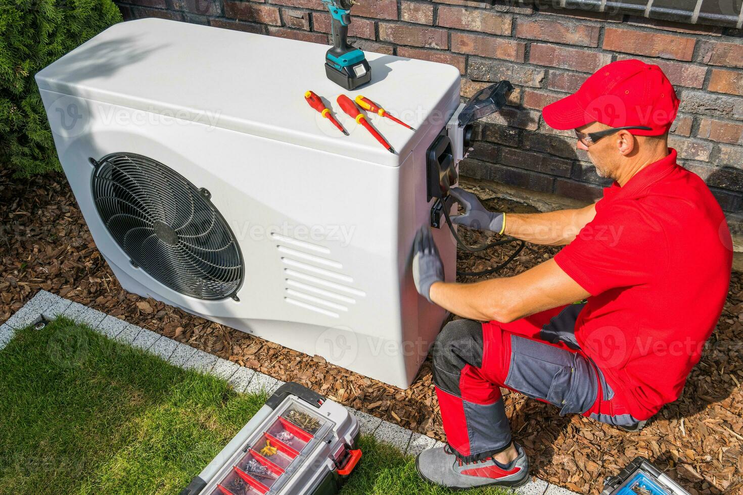 Technician Repairing Heat Pump Unit photo