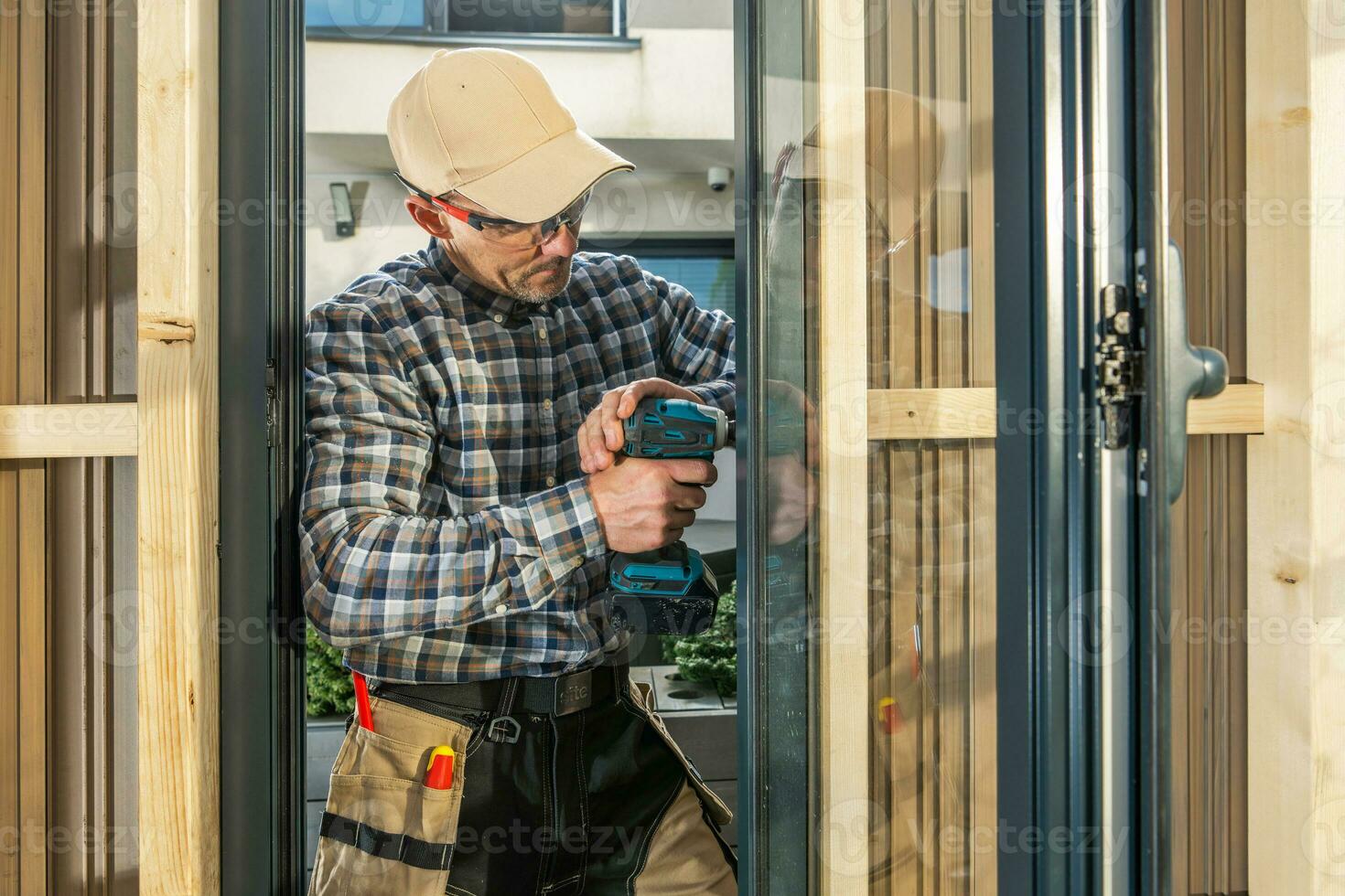 Caucasian Worker Installing Aluminium Made Window Inside a Wall photo