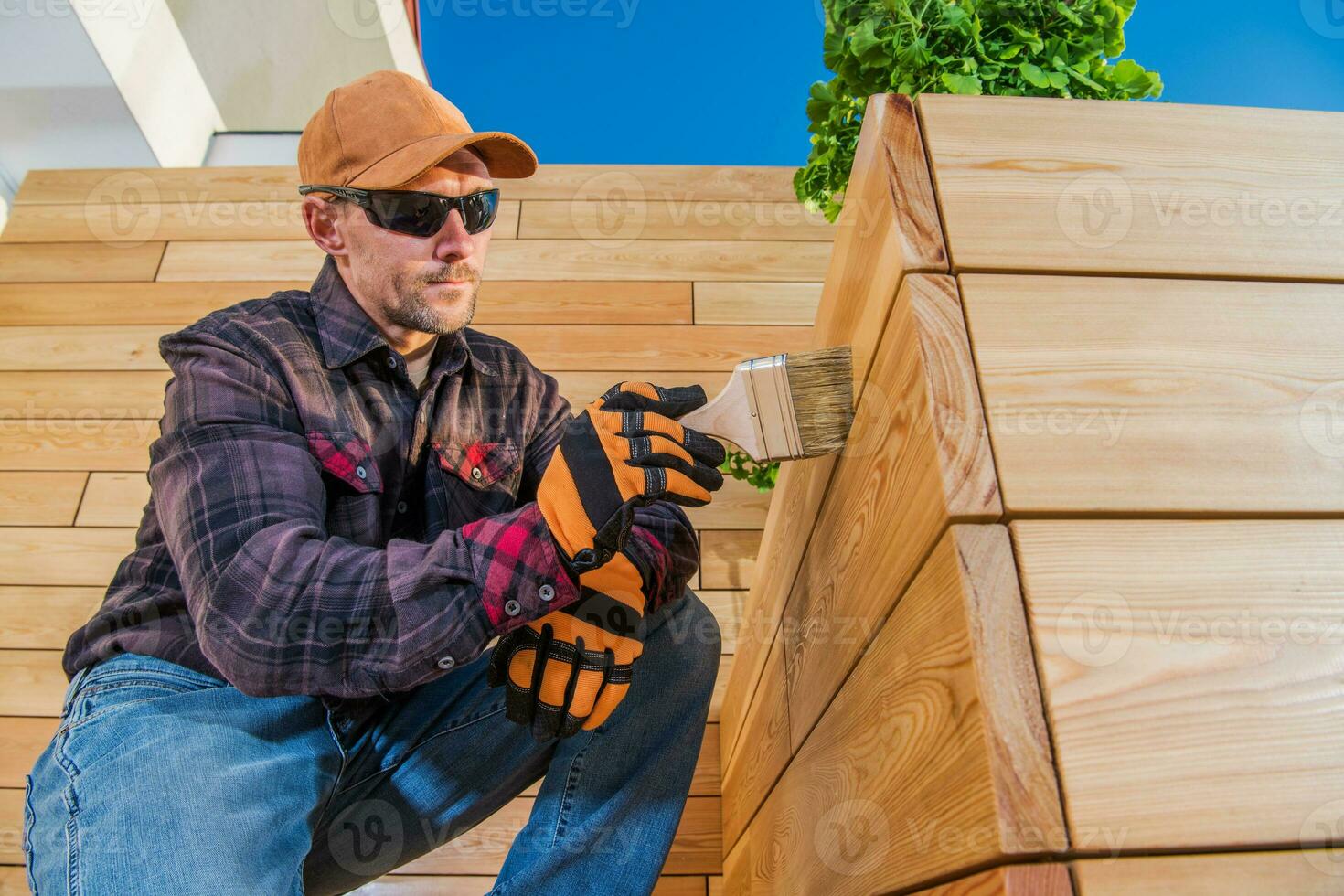 Painter Oiling Wooden Planks With Brush. photo