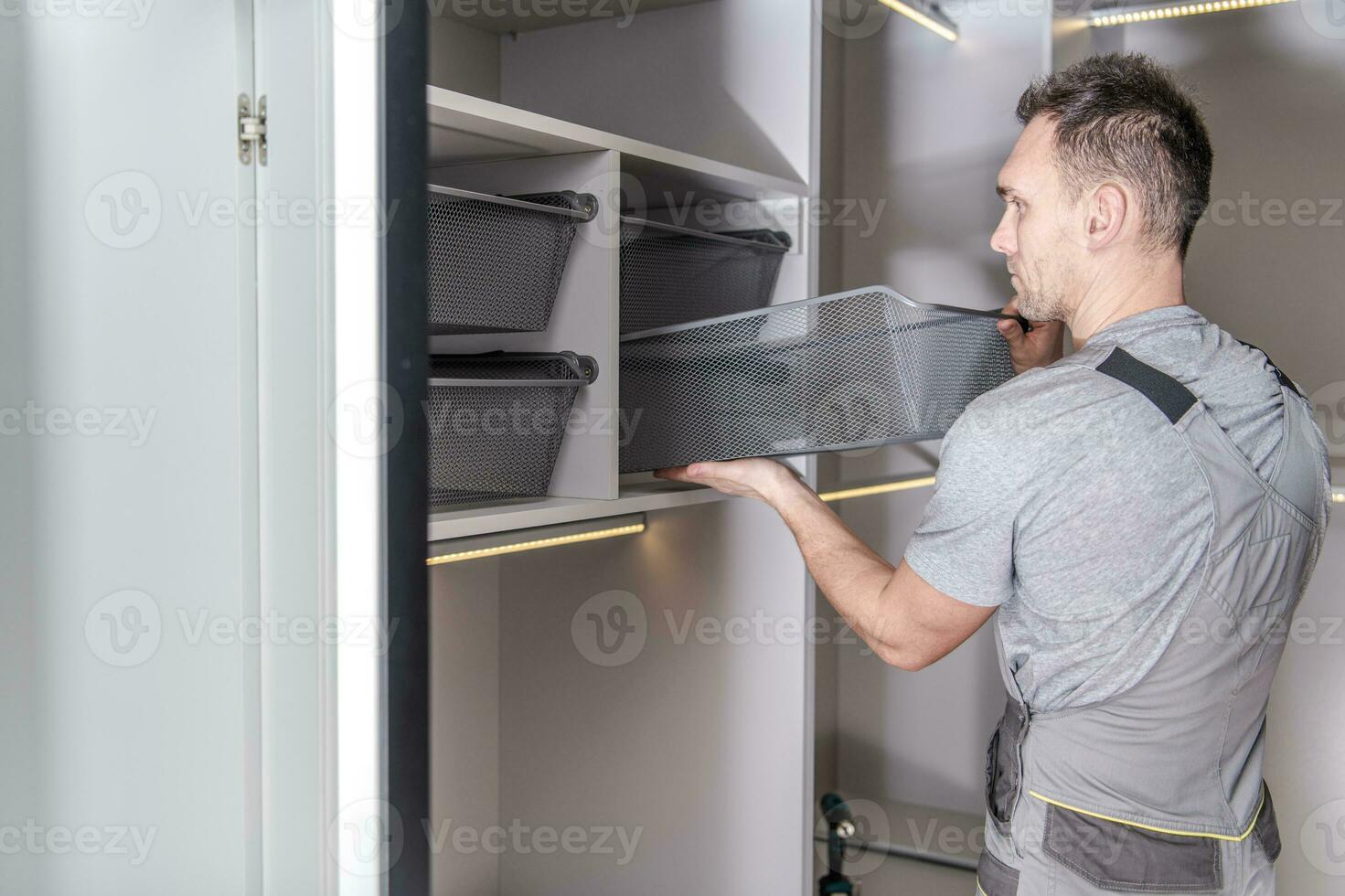 Male Handyman Finishes Installation Of Walk In Closet And Storage Area. photo