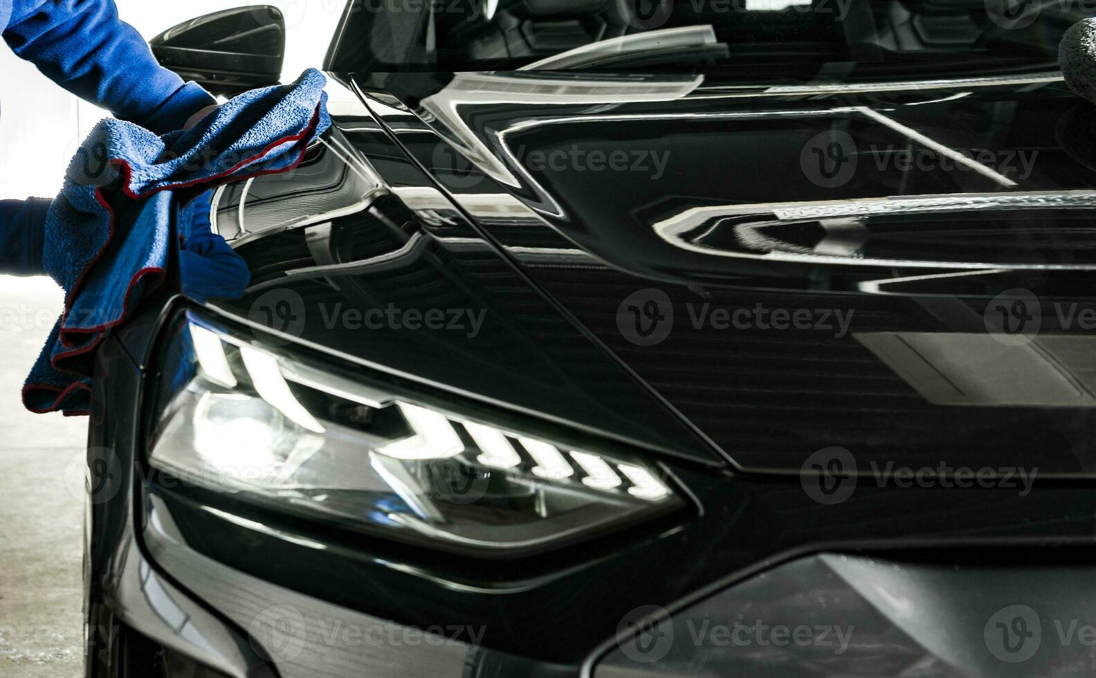 Car Wash and Detailing Worker Cleaning a Car with Soft Cloth photo