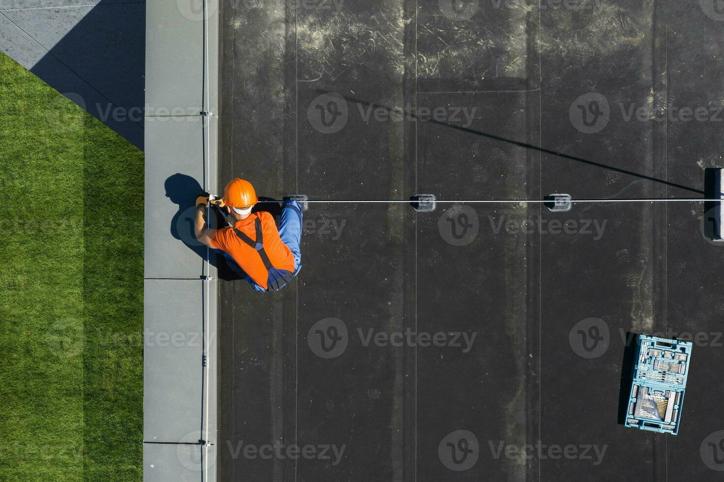 Technician Installing Lightning Protection Rod on Top of Building photo