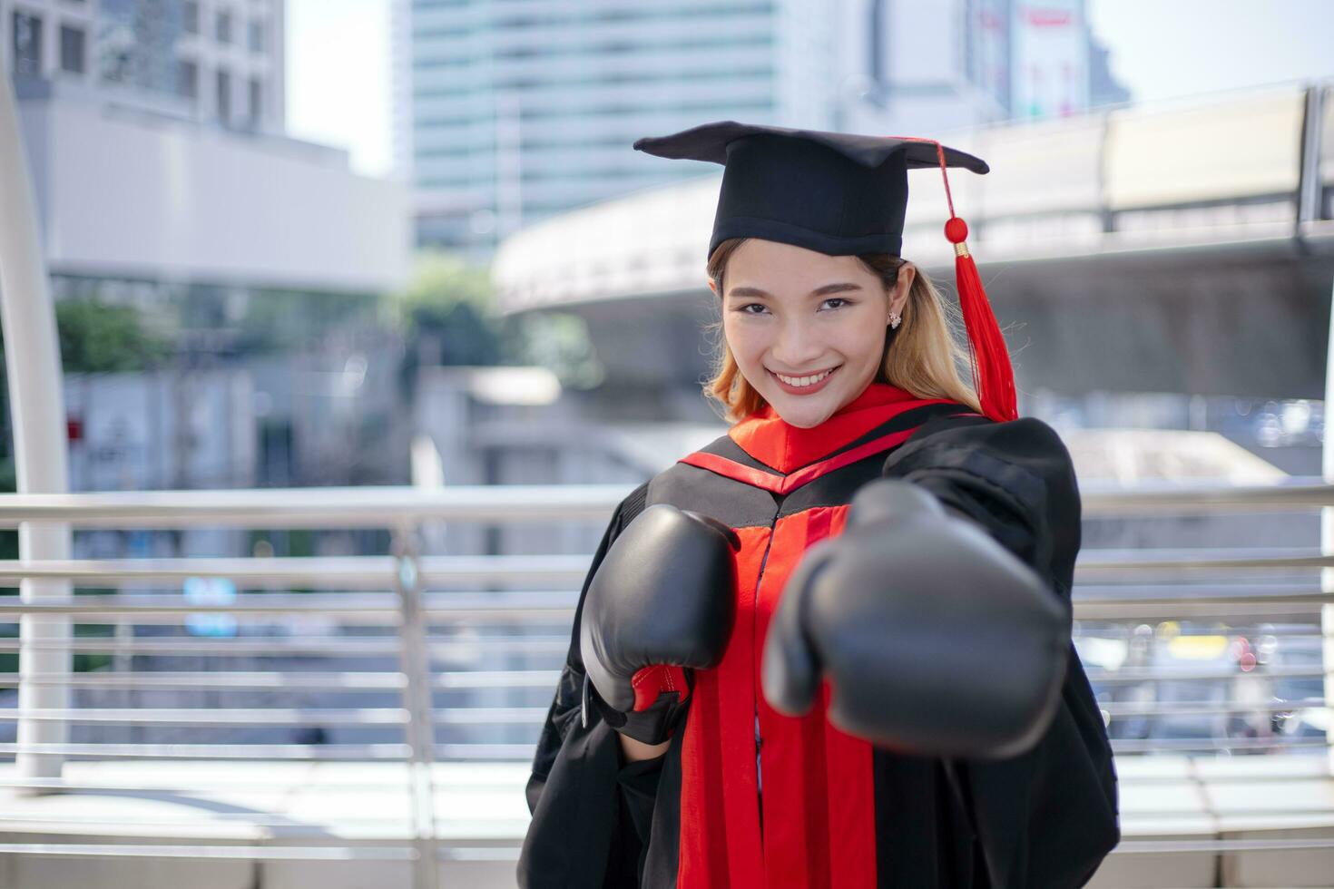 contento asiático estudiante graduado con boxeo guantes. foto