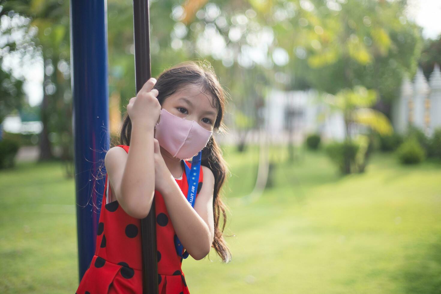 Happy girl with red dress playing at park. photo