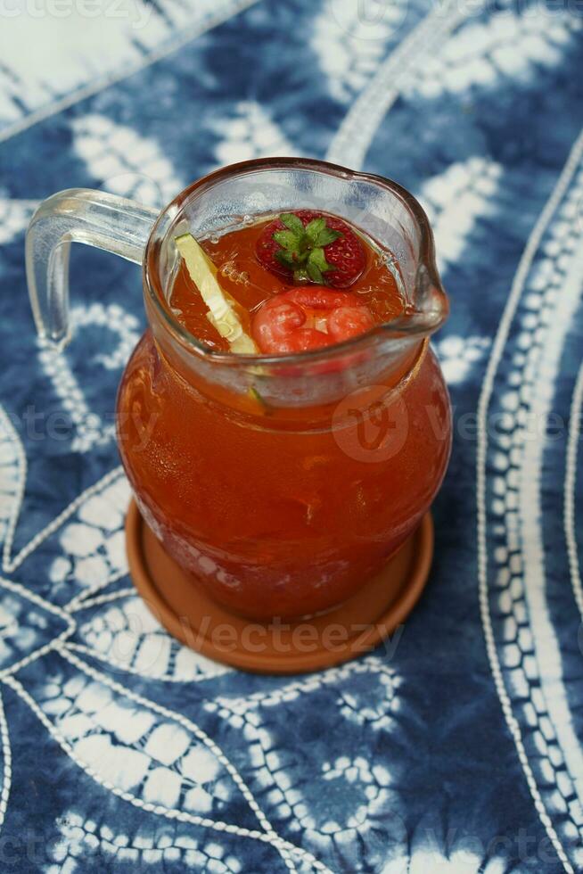 parte superior ver limón té en un vaso jarra en marrón lámina, en blanco y azul tela fondo, fruta, beber, salud, bandera, plantilla, Copiar espacio foto