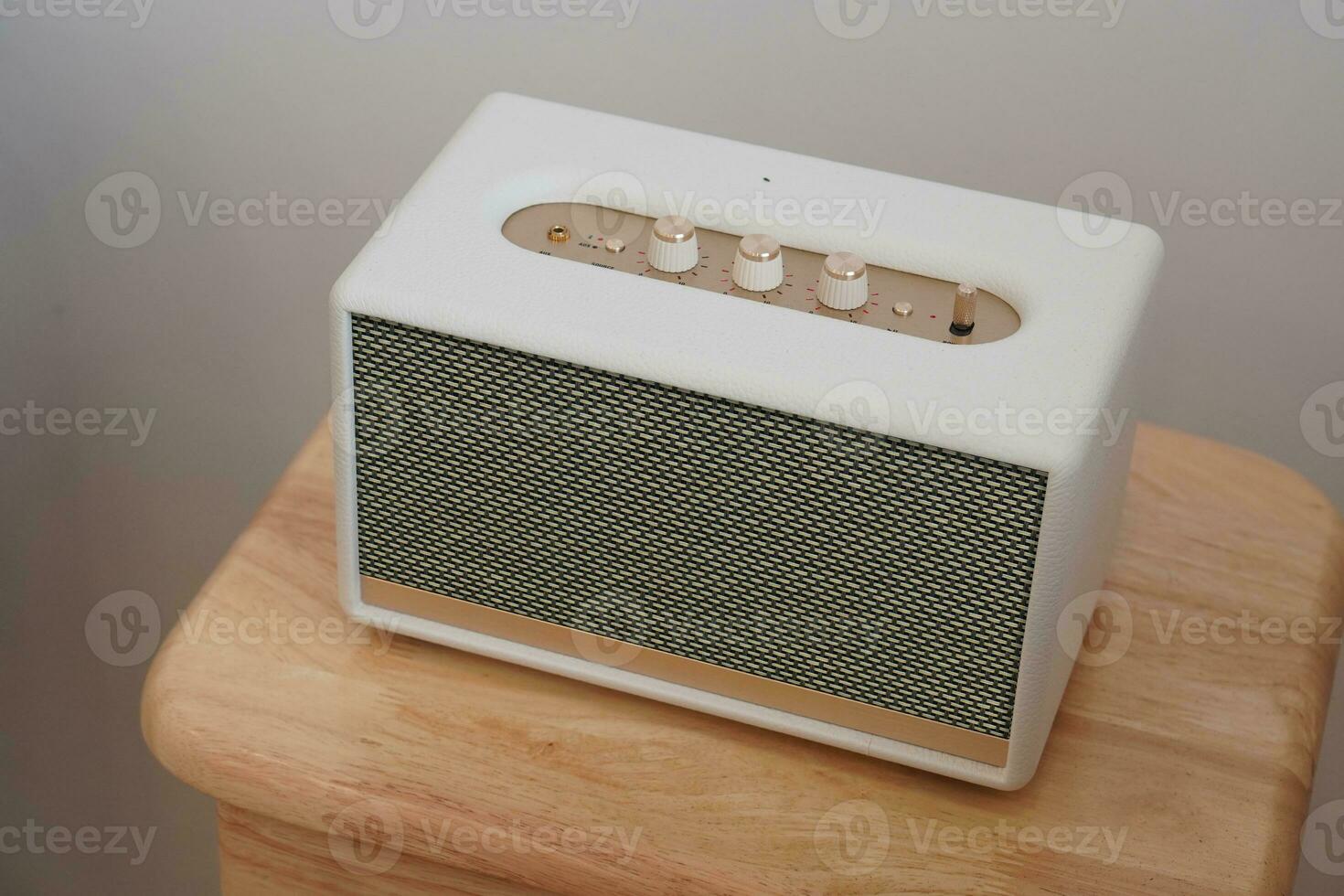 beautiful white and black, gold rectangular loudspeaker on wooden chair, white wall background, technology, object, fashion, decor, copy space photo