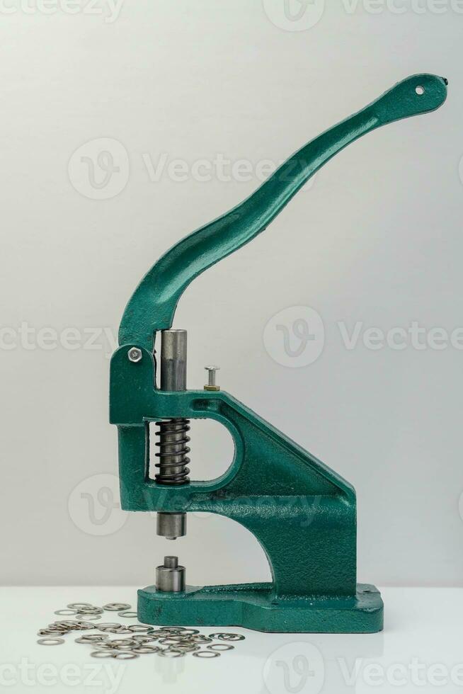 Side view Green steel Eyelet machine lever and Eyelet on white background photo