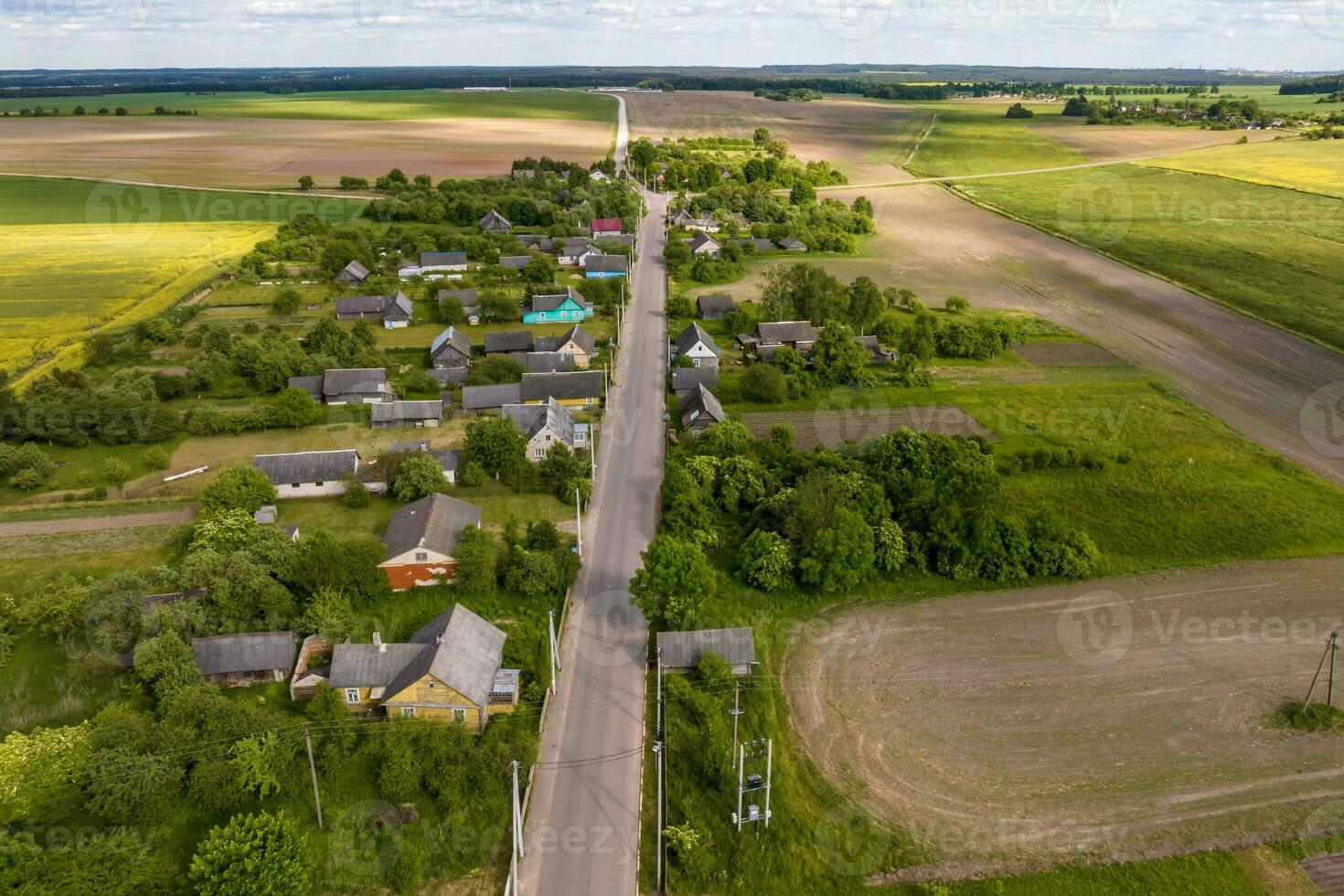 panoramic aerial view of eco village with wooden houses, gravel road, gardens and orchards photo