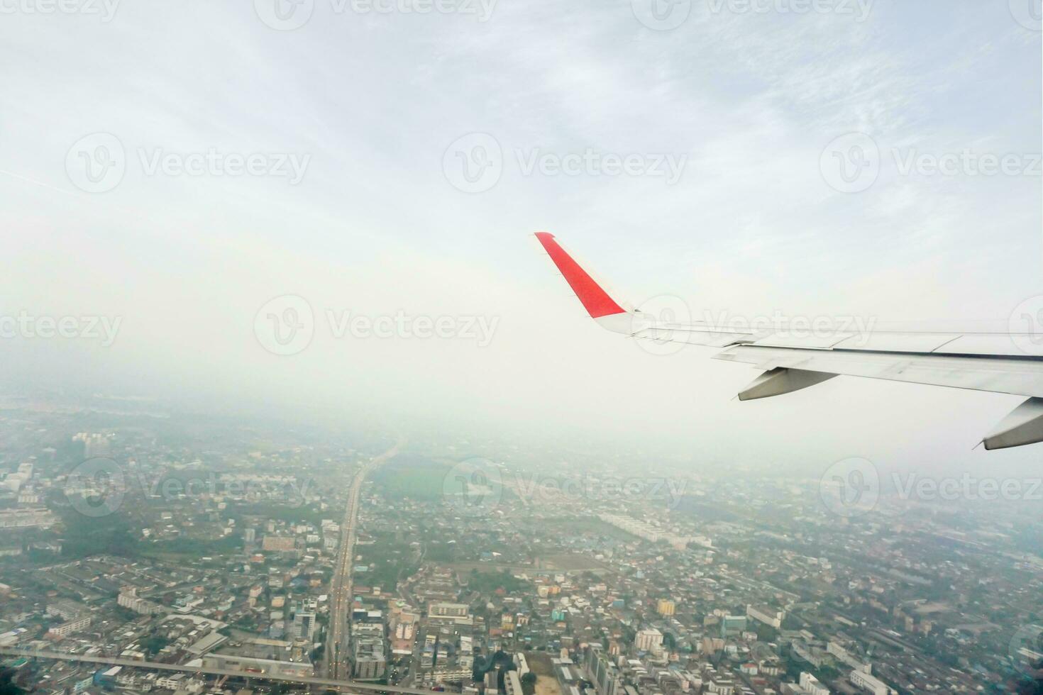 Outside aircraft window view with aircraft wing on blue sky and higher of landscape view background. photo