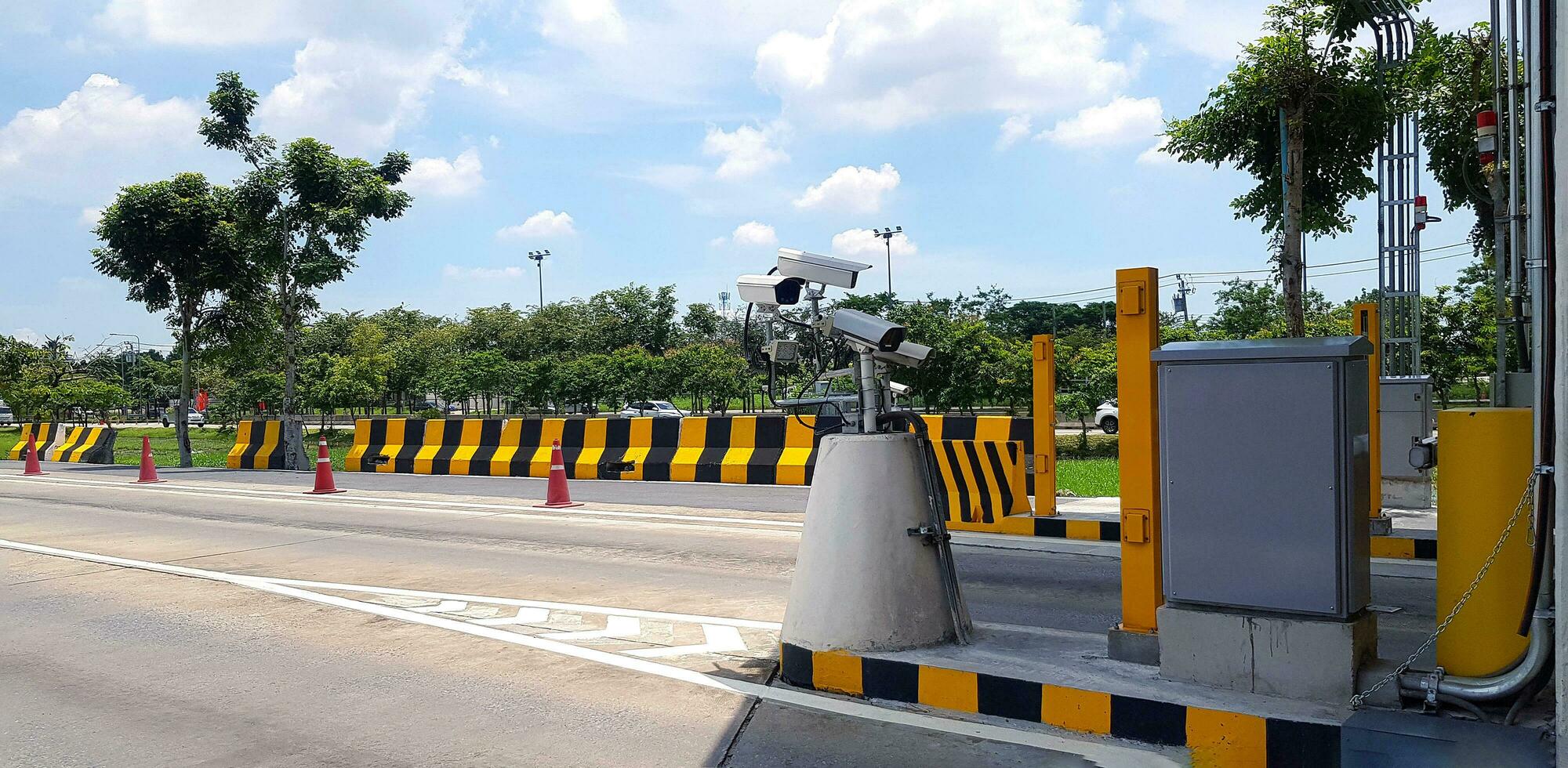 grupo de cctv cámara instalado para grabación accidente en la carretera o calle con pintado amarillo y negro barrera, árbol y cielo antecedentes. proteccion, observar tráfico foto