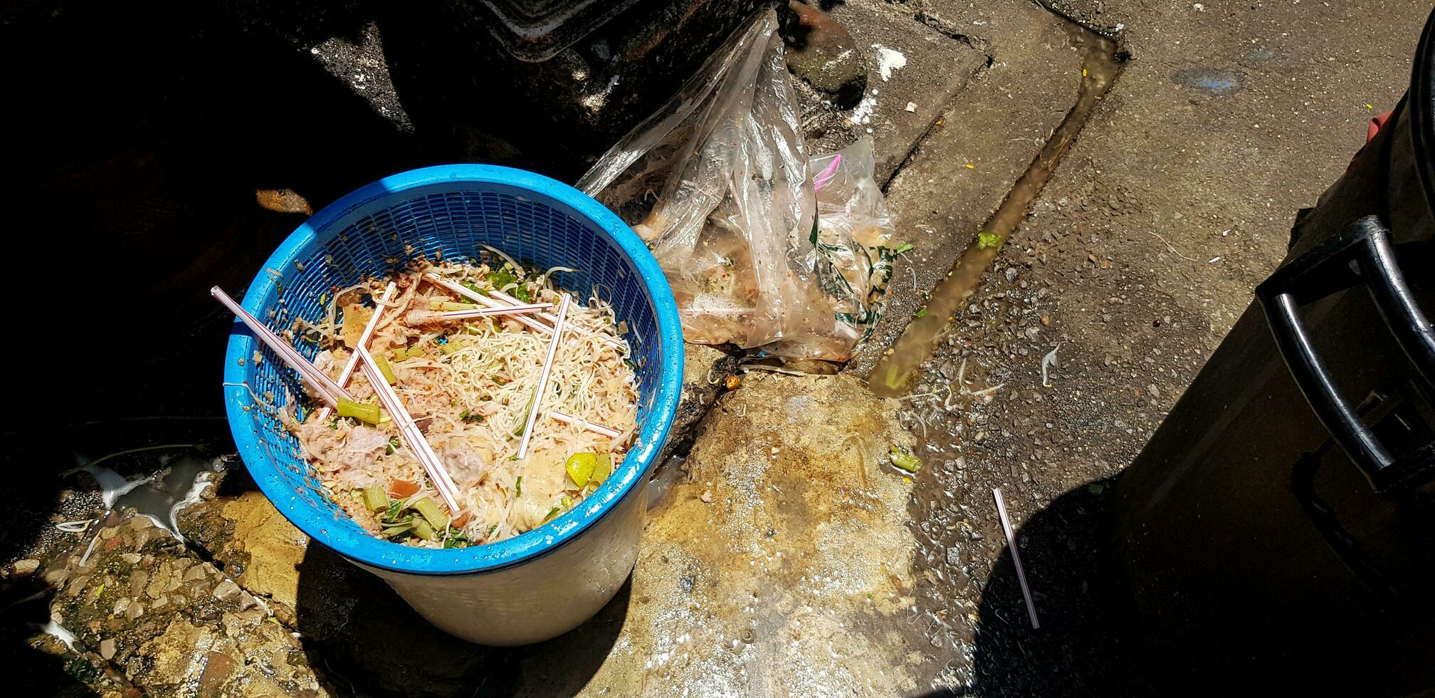 muchos comida residuos en el azul cesta en el calle. sucio sitio y antihigiénico concepto foto