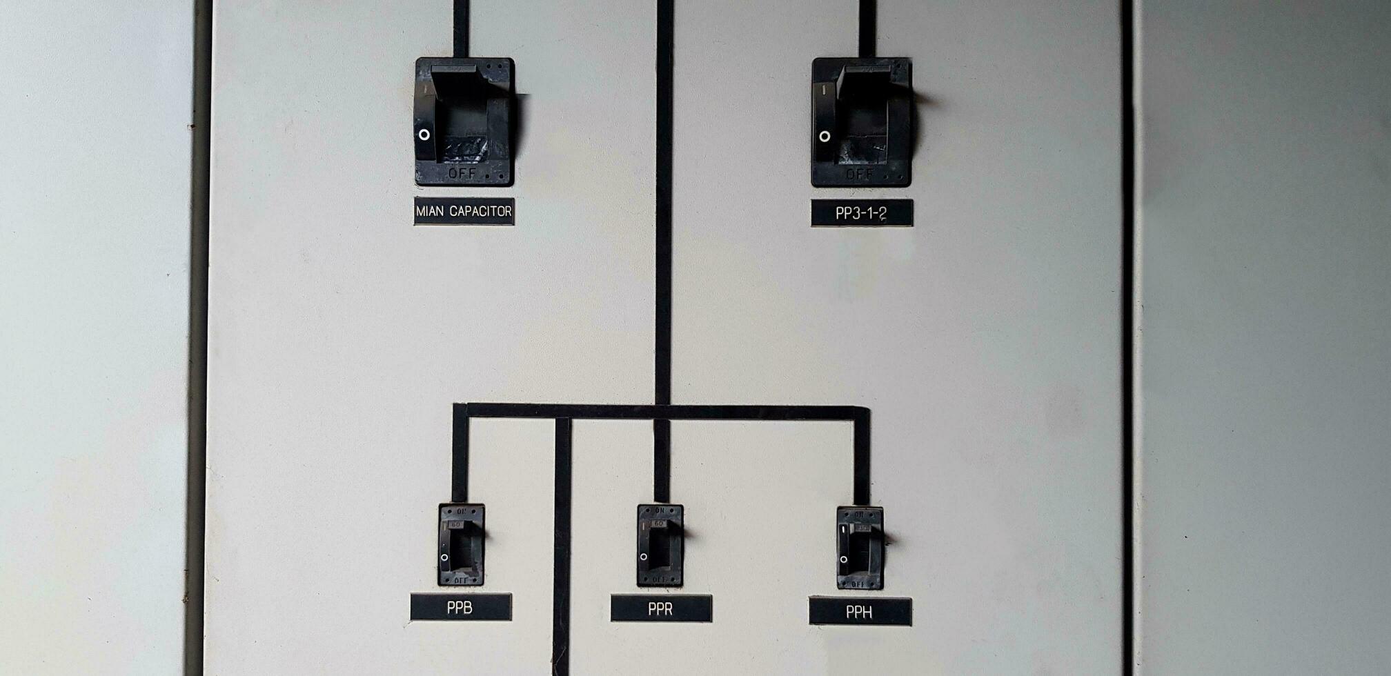 Black electrical main breaker connect with small switch on gray or grey stainless steel cabinet for distribution electric current to switch or device in the power room photo