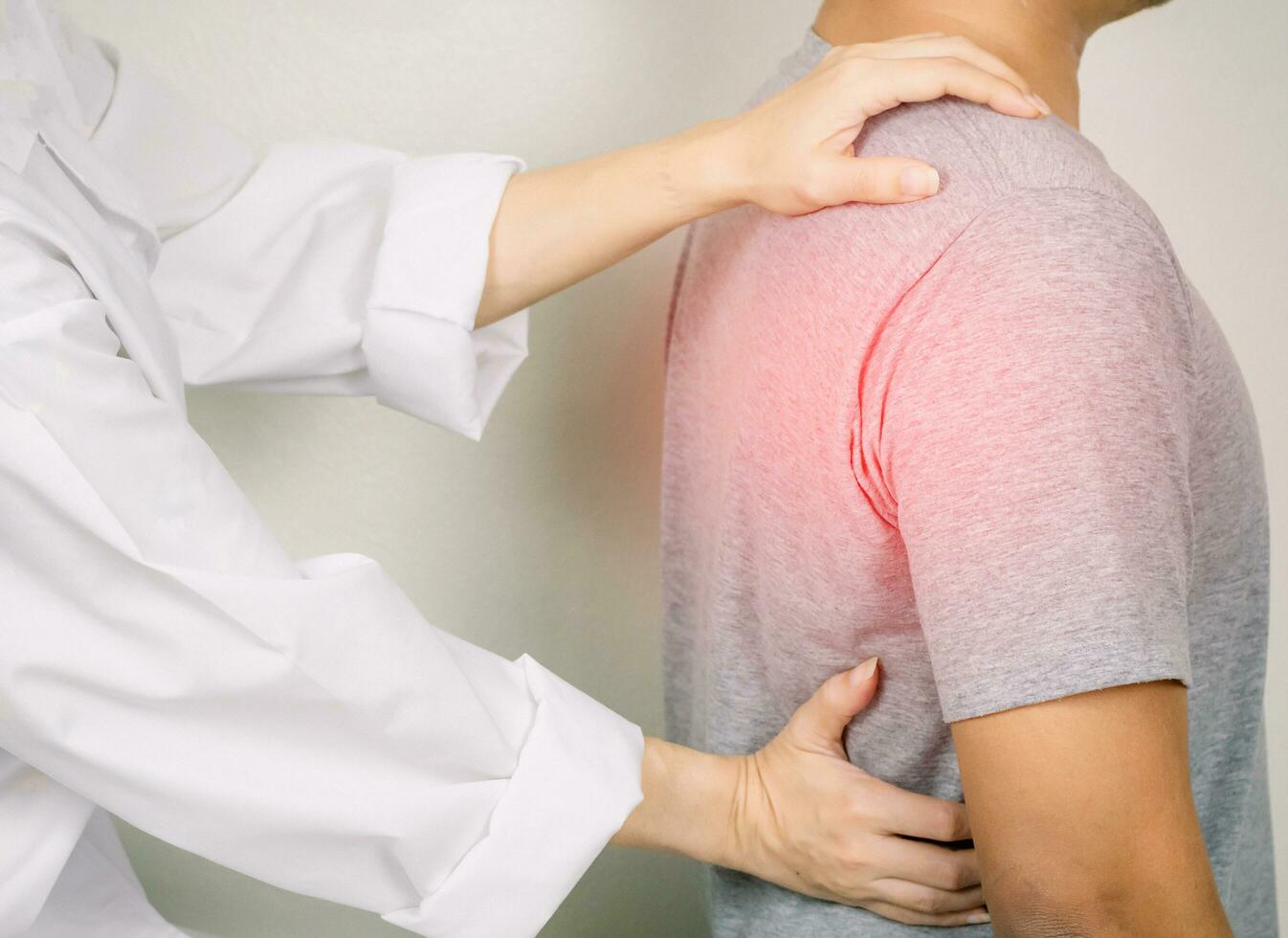 The doctor examines a patient with back pain Inflammation of the back photo