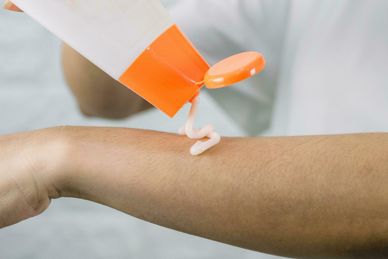 A woman applying a skin care cream arm photo