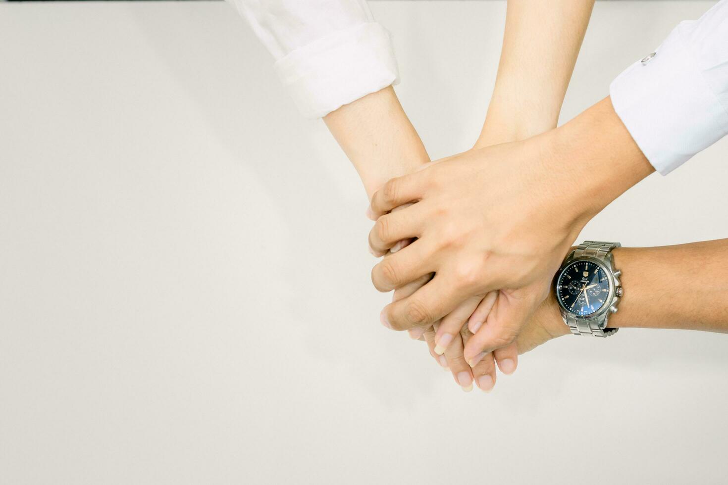 hands showing unity and teamwork clasped cooperation top view of people putting their hands photo