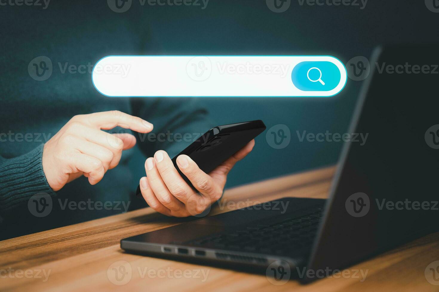 Adult man hand working with a mobile phone and computer laptop on the desk. Searching browsing internet data information with blank search bar. Search Engine Optimization SEO networking concept. photo