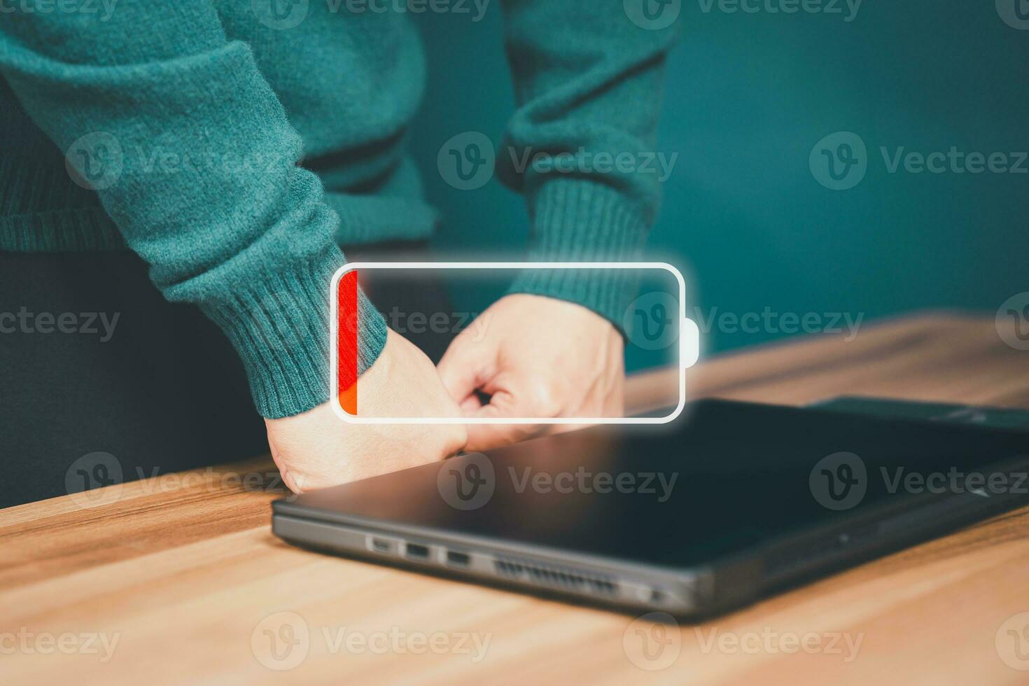 Young man is angry and frustrated when he learns that his the laptop computer's battery is dead and did not bring the charger adapter. photo