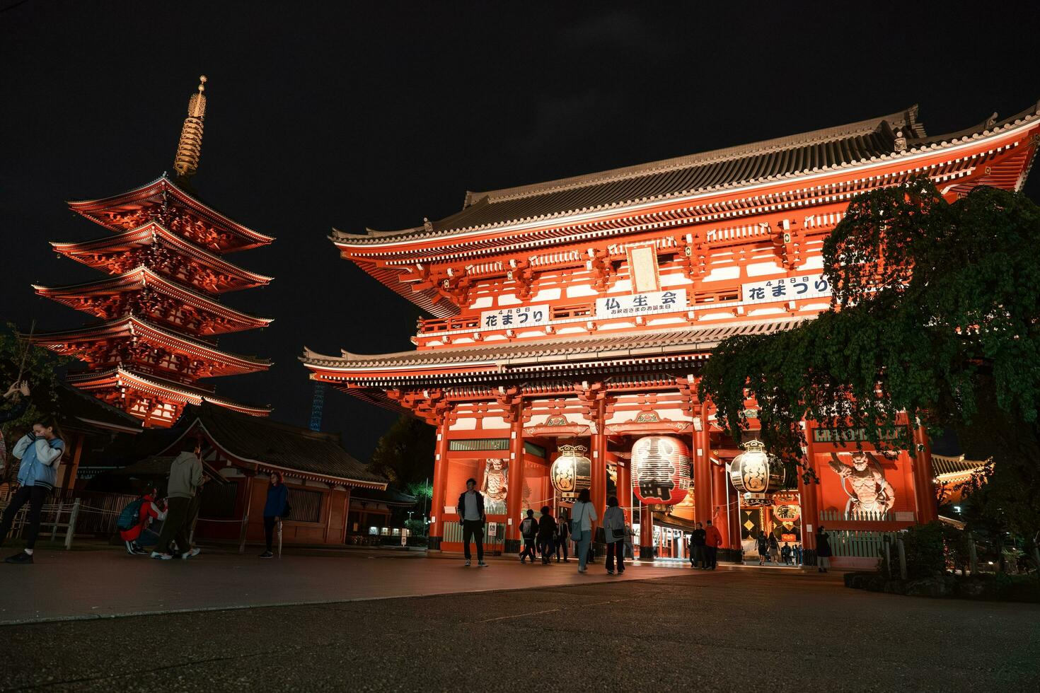 TOKYO, JAPAN - APRIL 7, 2023 People walking around Senso-ji temple in Asakusa area in the evening with rain drizzle photo