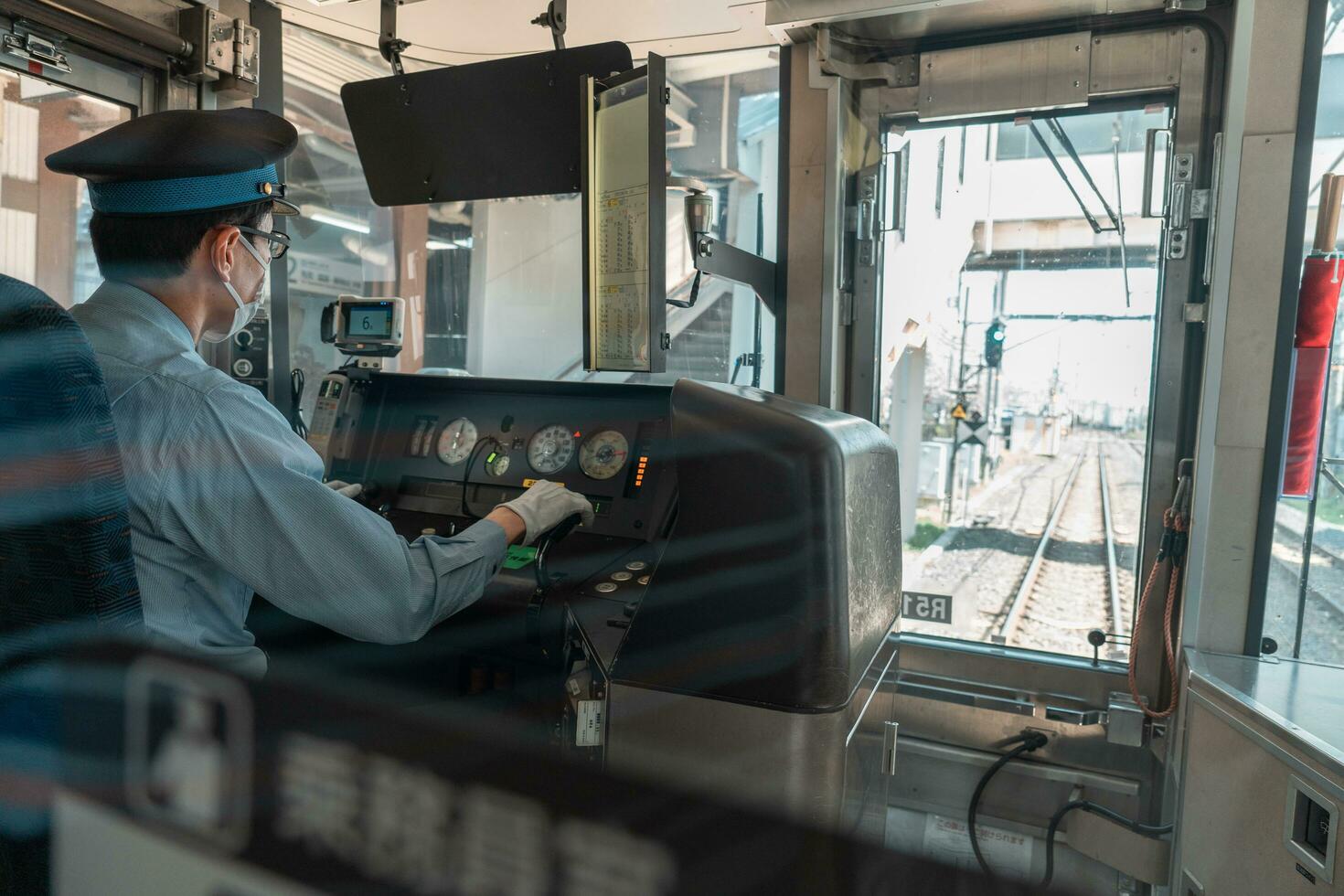 Asian male train driver on workplace, view from behind photo