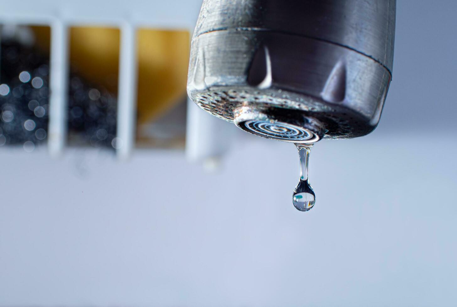 Water droplets from an old aluminum faucet with rust stains on it. water dripping from the faucet photo