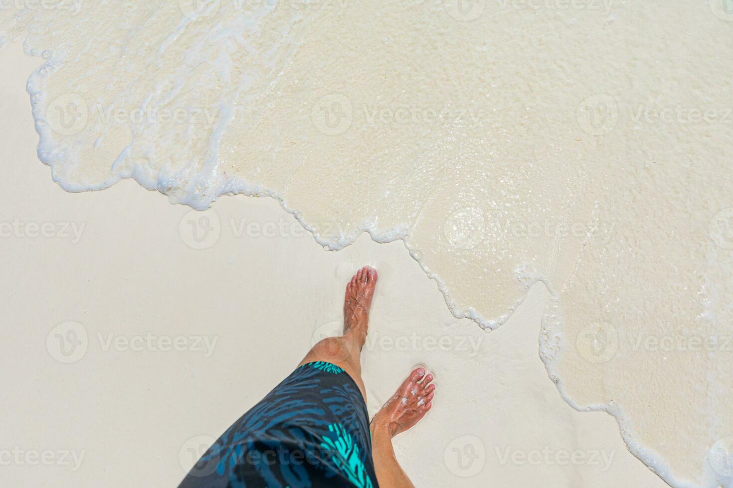 White sandy feet with waves on the beach, top view. Summer vacation and holiday concept of travel and tourism. Amazing summer mood and vibes, beach photo