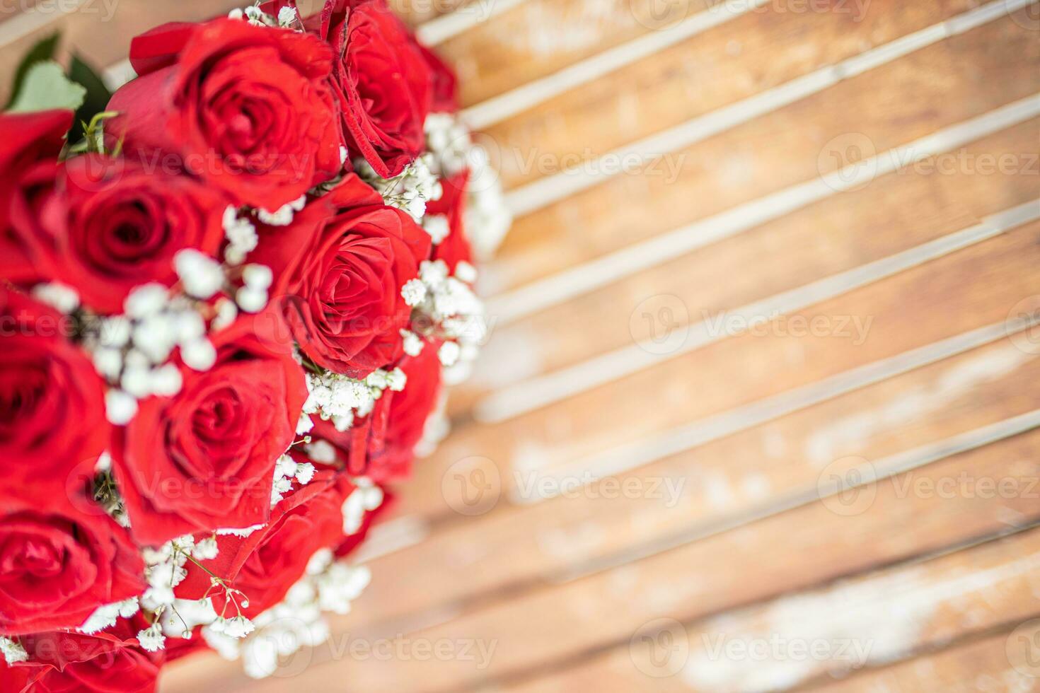 Romantic red roses in a rustic background. Flower arrangement of roses on shabby wooden background. Greeting card concept. Wedding or anniversary artistic concept photo