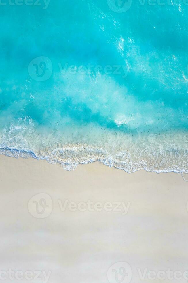 Summer seascape beautiful waves, blue sea water in sunny day. Top view from drone. Sea aerial view, amazing tropical nature background. Beautiful bright sea with waves splashing and beach sand concept photo