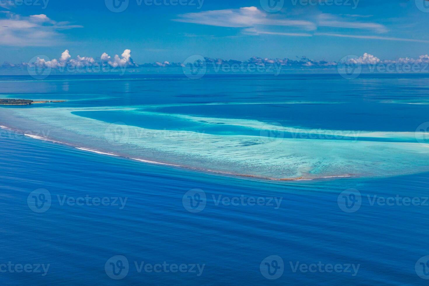 Tropical islands and atolls in Maldives from aerial view. Famous travel destination and luxury vacation or summer holiday concept. Aerial landscape of blue sea and resorts, hotels. Beautiful nature photo