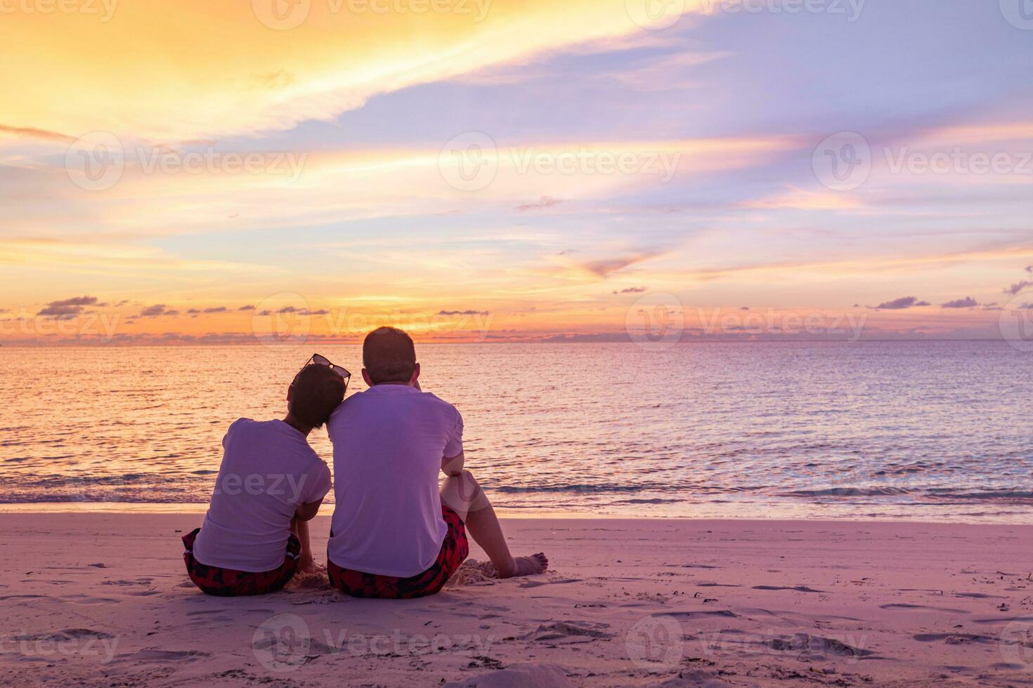 Romantic couple on the beach at colorful sunset on background. Perfect tropical sunset landscape, exotic nature view. Happy romantic couple enjoying beautiful sunset at the beach photo