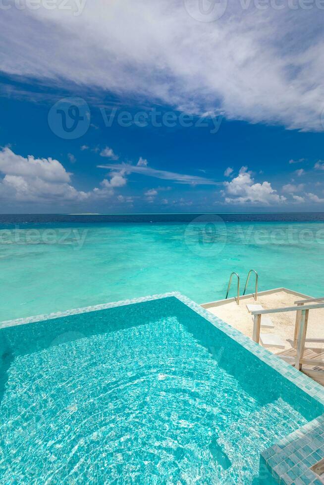 Enjoy the ocean view infinity pool on vacation. Dream scene, endless pool into perfect tropical blue azure sea. Amazing summer scenery in luxury resort hotel. Exotic landscape photo