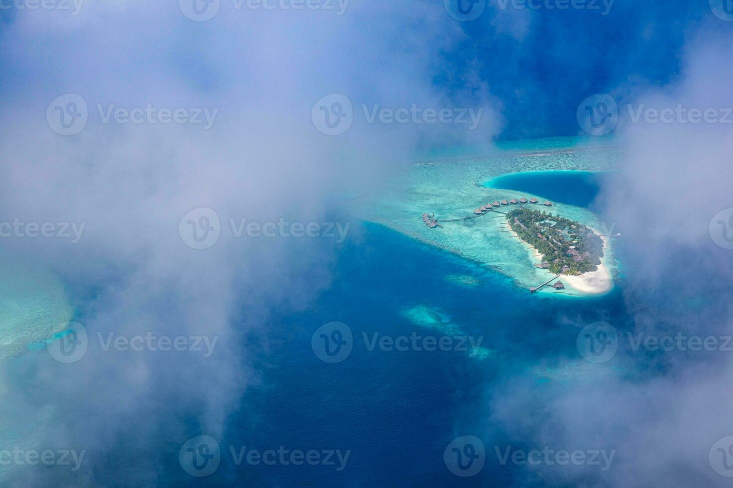 Tropical islands and atolls in Maldives from aerial view. Famous travel destination and luxury vacation or summer holiday concept. Aerial landscape of blue sea and resorts, hotels. Beautiful nature photo