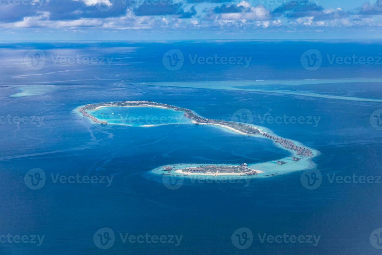 islas tropicales y atolones en maldivas desde vista aérea. famoso destino de viaje y vacaciones de lujo o concepto de vacaciones de verano. paisaje aéreo de mar azul y resorts, hoteles. Hermosa naturaleza foto