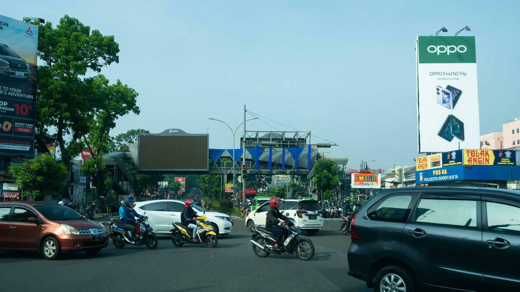 Bogor, West Java, Indonesia, May 2 2023 - Very heavy traffic of cars and motorcycle at one of the intersections of Bogor city during a sunny day. photo