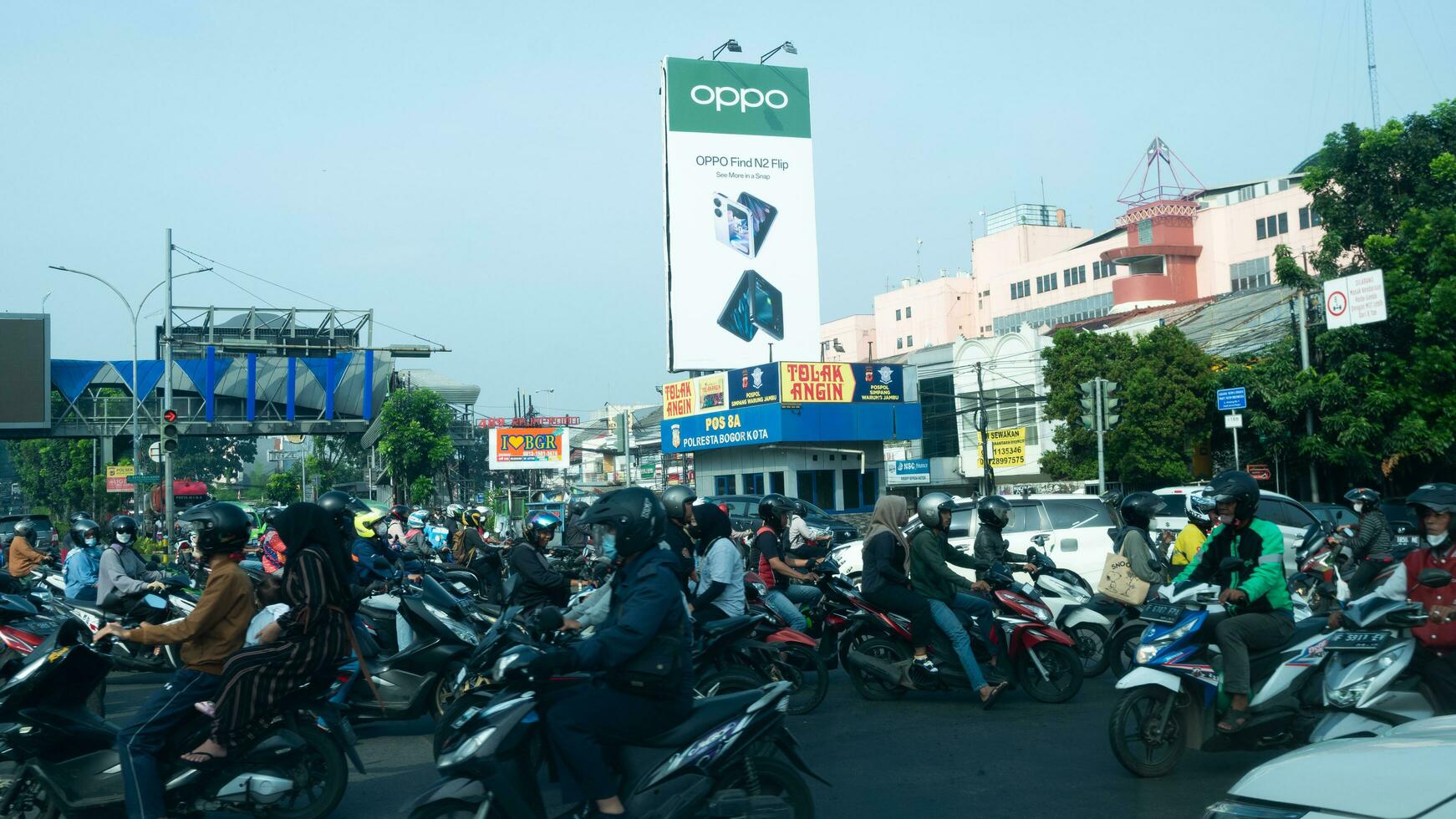 Bogor, West Java, Indonesia, May 2 2023 - Very heavy traffic of cars and motorcycle at one of the intersections of Bogor city during a sunny day. photo