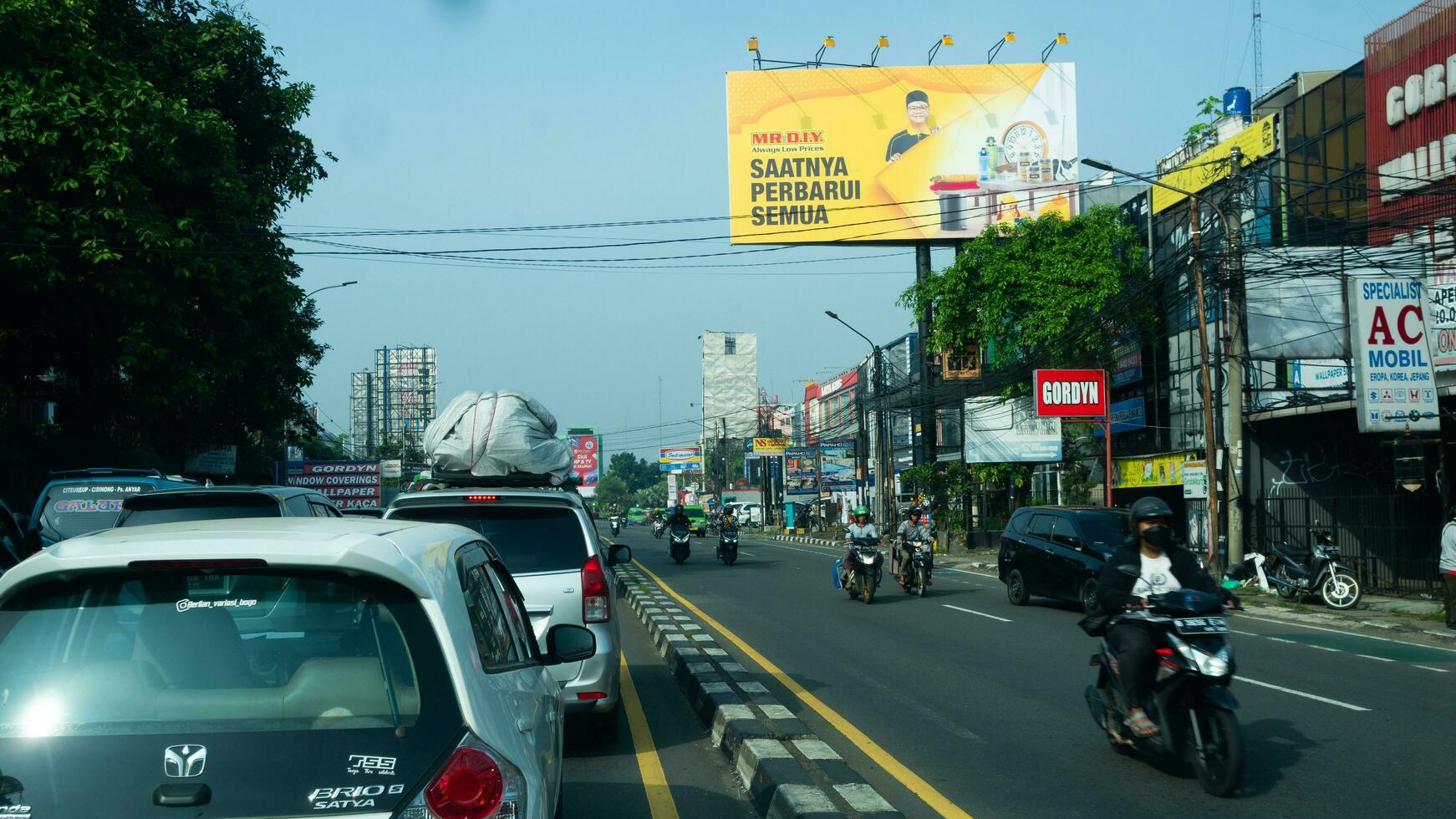 Bogor, West Java, Indonesia, May 2 2023 - Very heavy traffic of cars and motorcycle at one of the intersections of Bogor city during a sunny day. photo