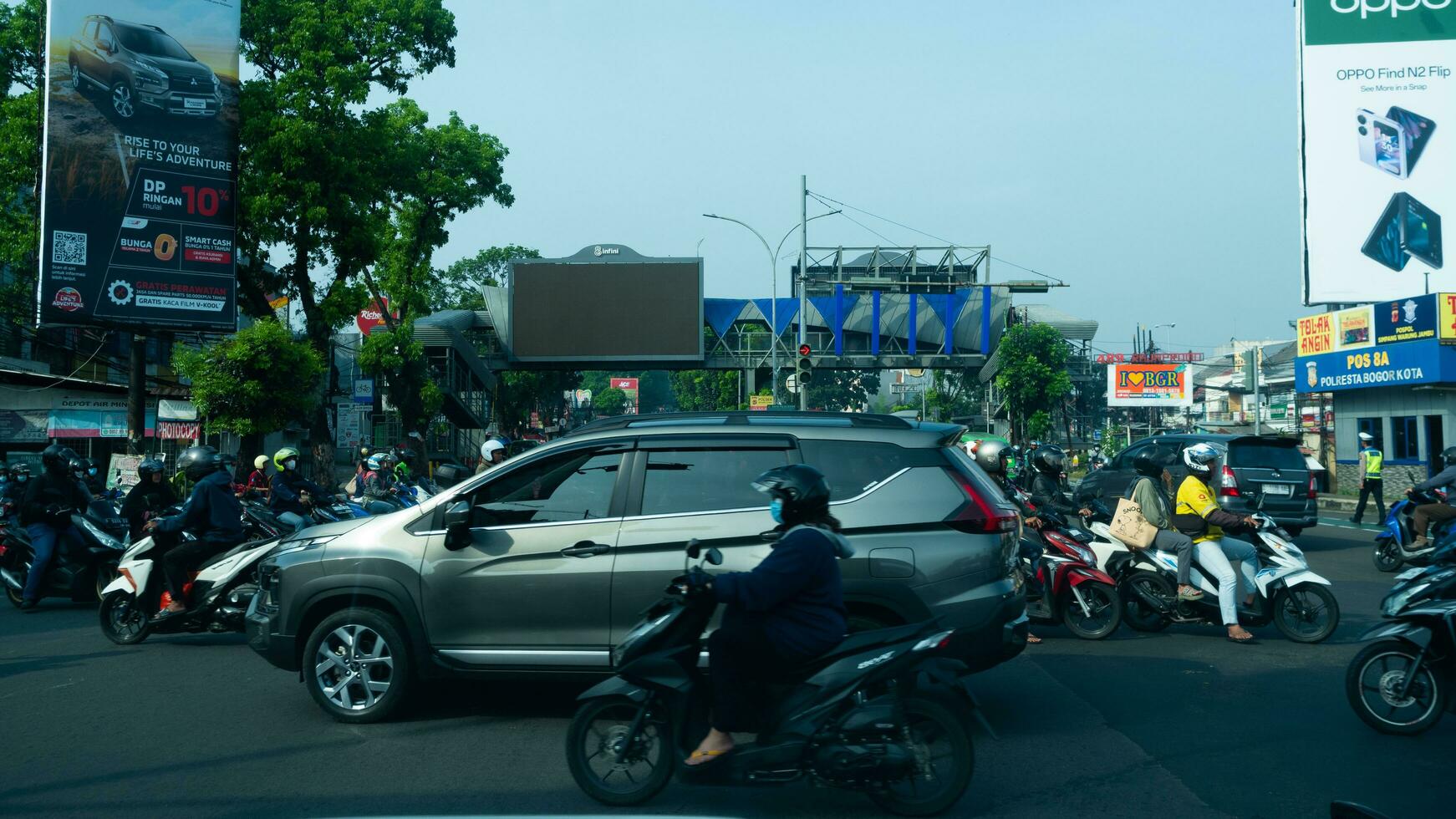 Bogor, West Java, Indonesia, May 2 2023 - Very heavy traffic of cars and motorcycle at one of the intersections of Bogor city during a sunny day. photo