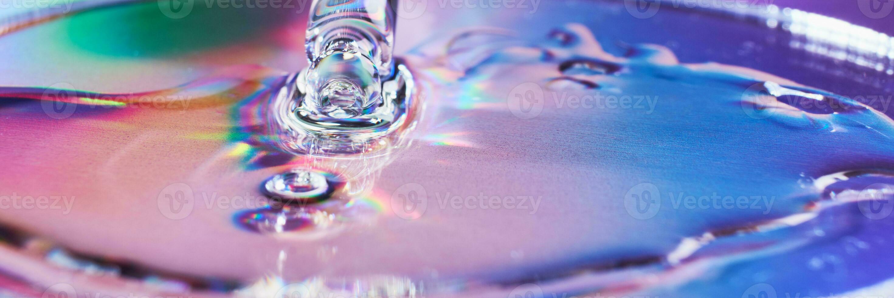 Pipette with cosmetic product on holographic banner, iridescent highlights, selective focus photo