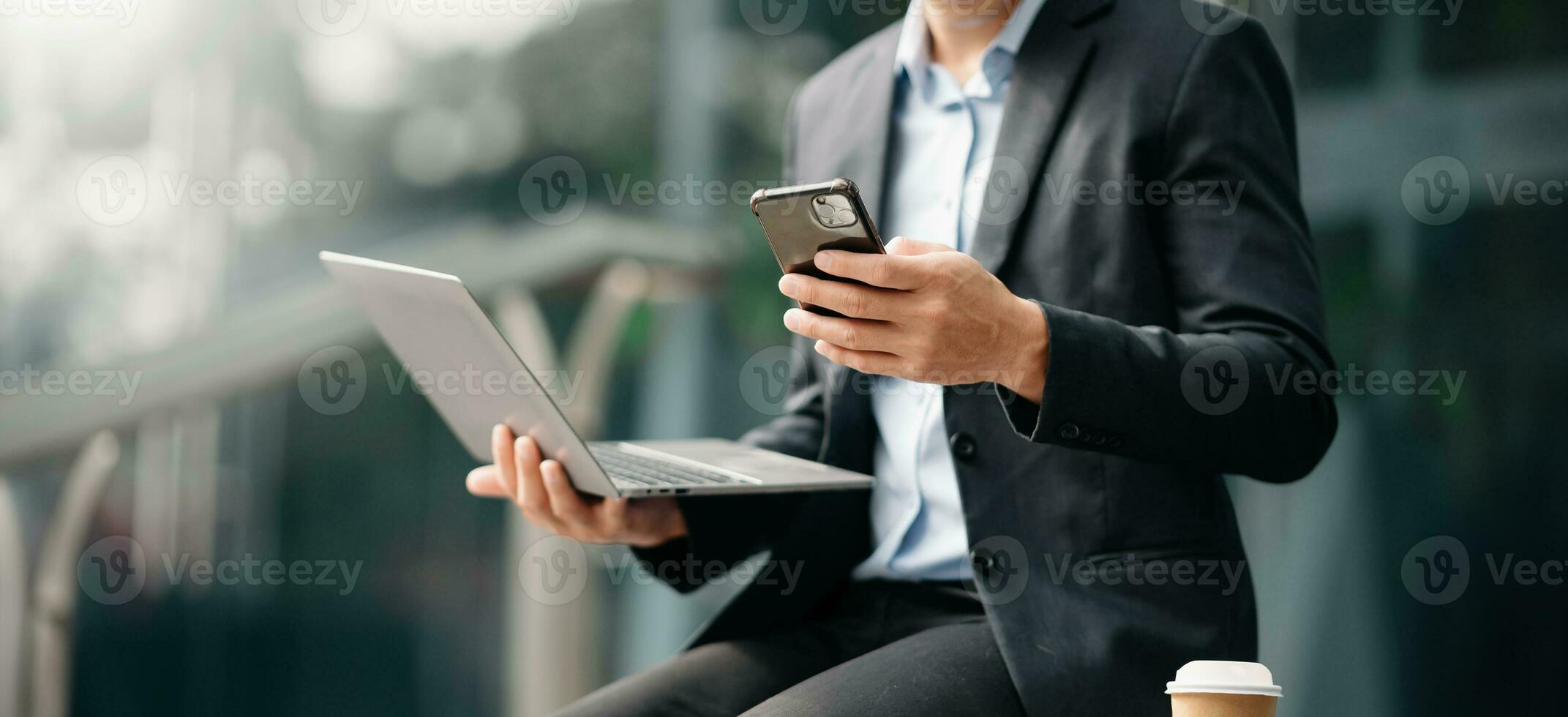 Businesswoman s hands typing on smartphone and  laptop keyboard in morning light computer, typing, online in outside office photo