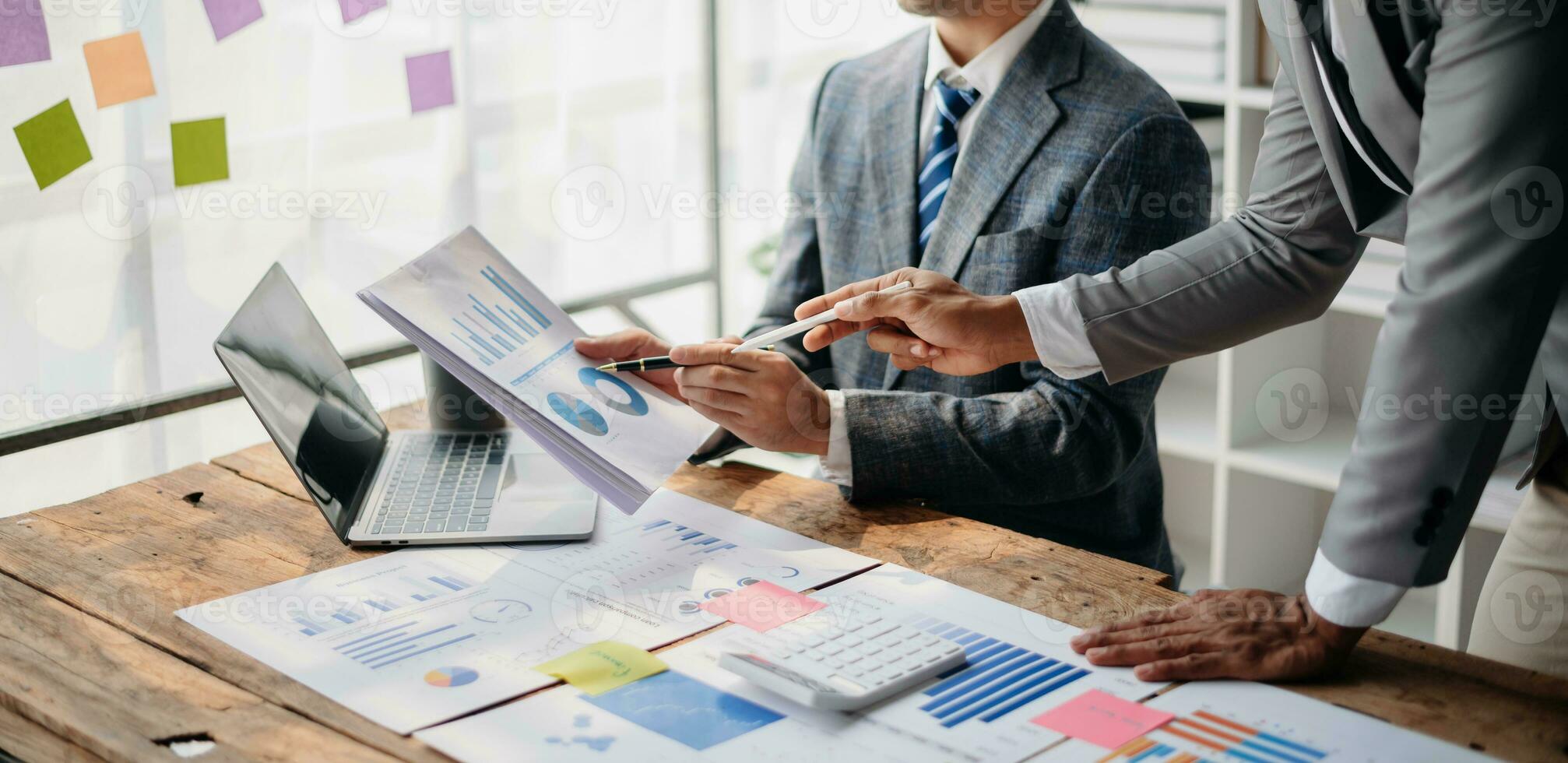 Business People Talking Discussing with financial document data charts and graphs Team business meeting with smart phone and laptop and digital tablet computer photo