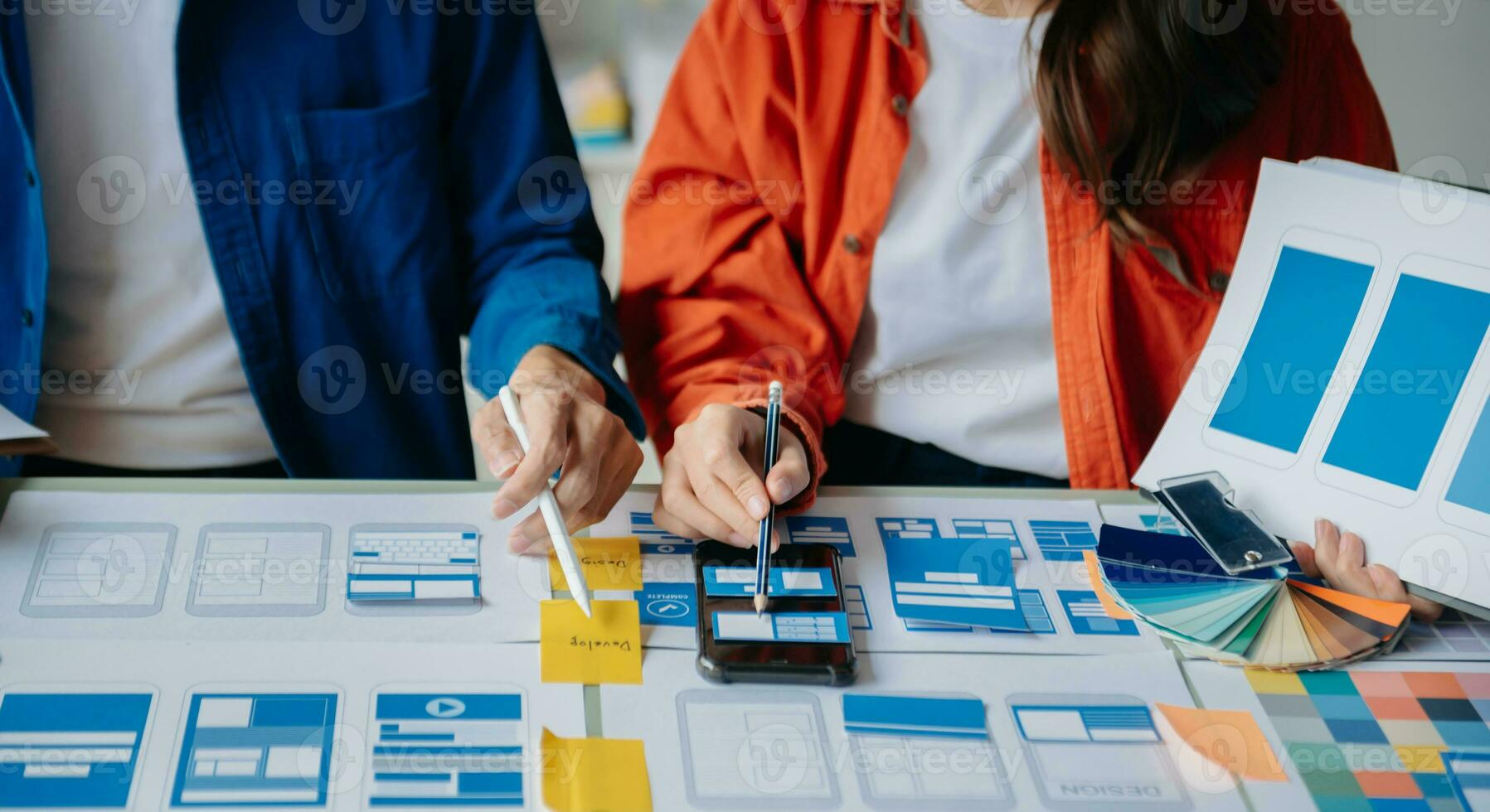 UX developer and ui designer brainstorming about mobile app interface wireframe design with customer breif and color code at modern office. photo