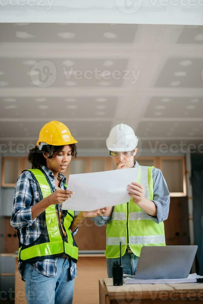 Engineers are discussing data working and laptop or tablet with architectural project at new construction site on big project. photo