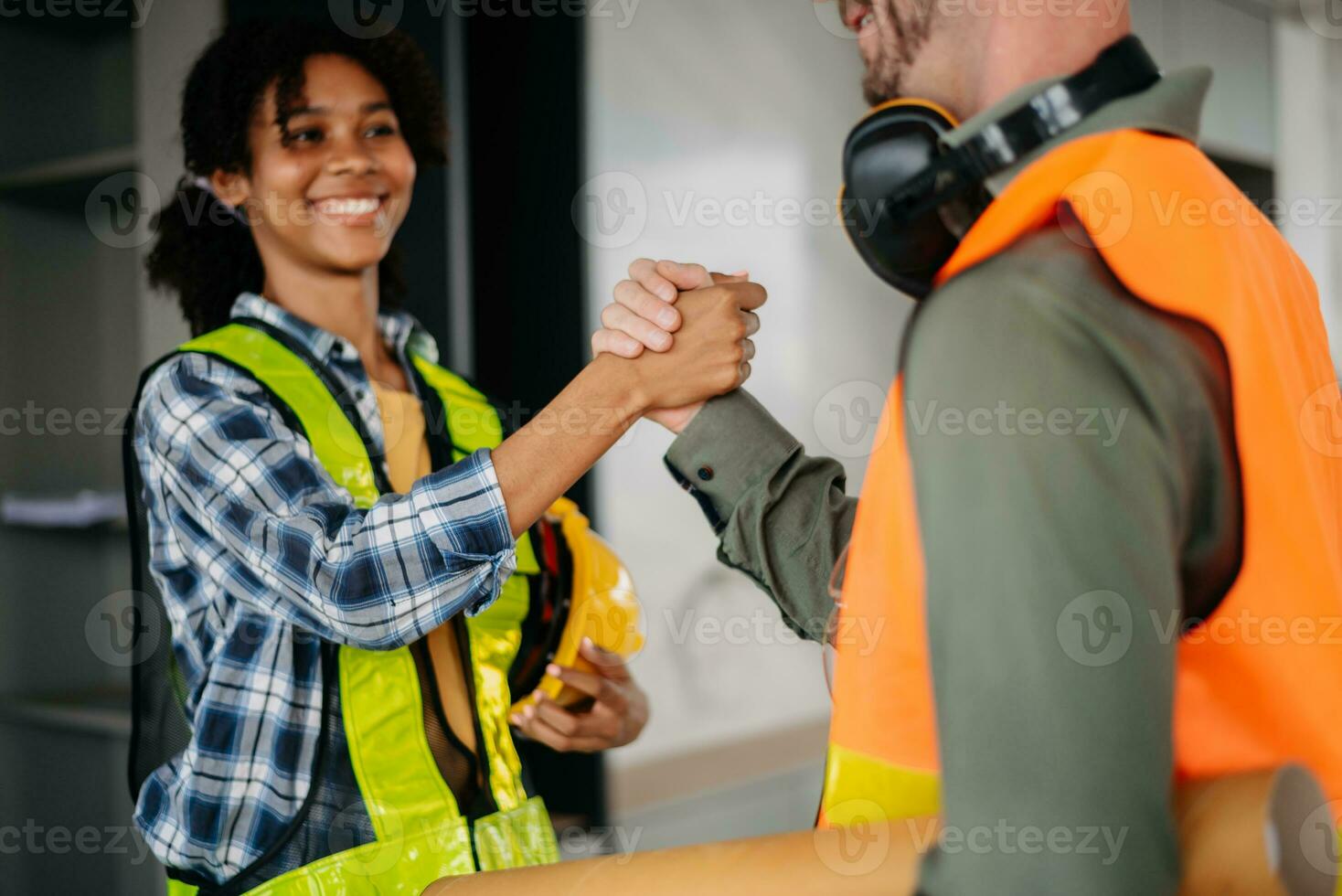 Construction team shake hands greeting start new project plan behind yellow helmet in office center to consults about their building project. photo