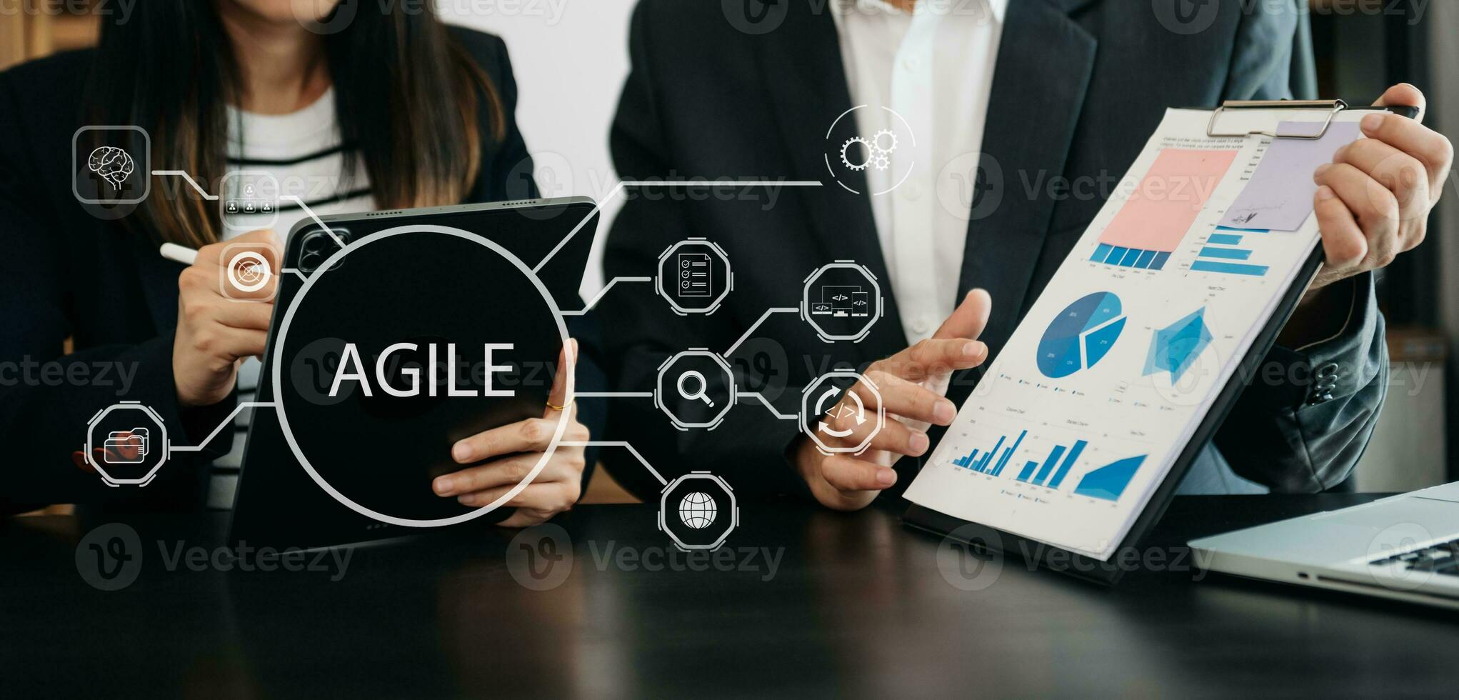 Agile development methodology concept. Business hand using laptop computer and tablet with virtual screen Agile icon on office digital technology concept. photo