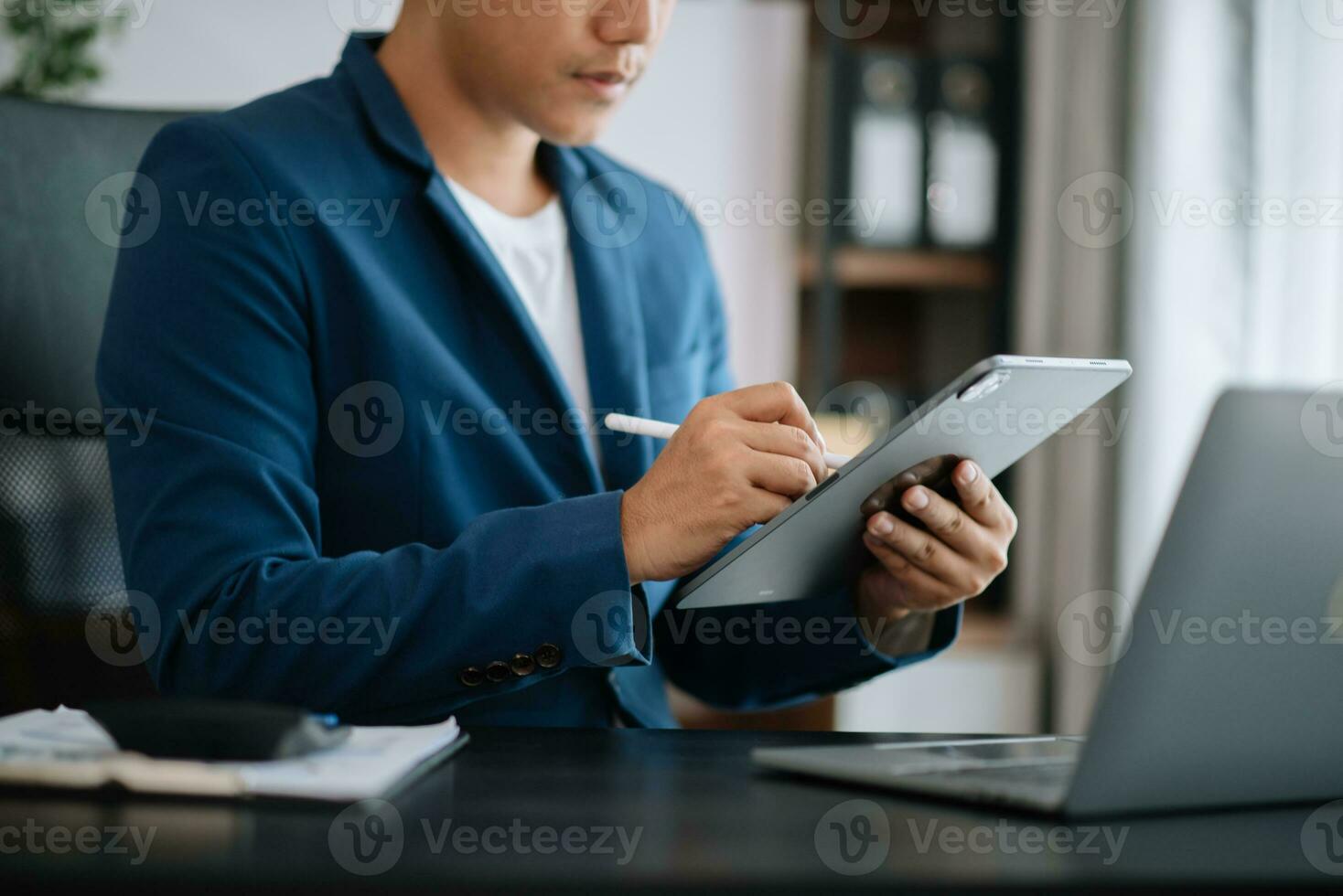 Businessman hand working digital marketing media in virtual screen with mobile phone and modern compute with diagram at office photo