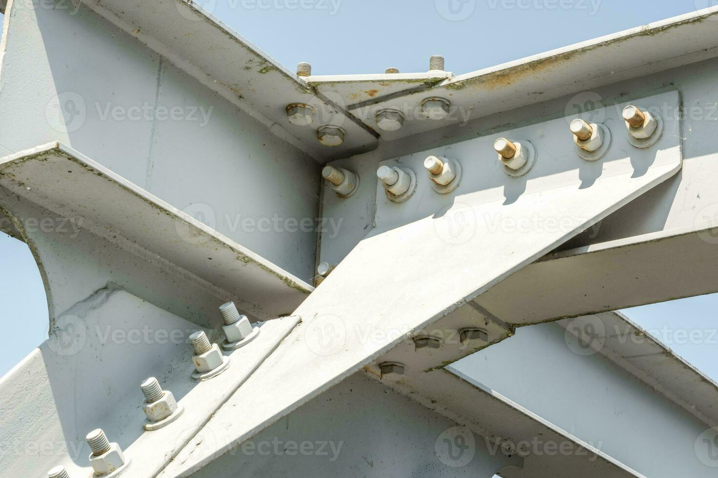 Bolts and nuts on metal plates of steel structure of heavy duty straight crossbar of frame and bridge support photo