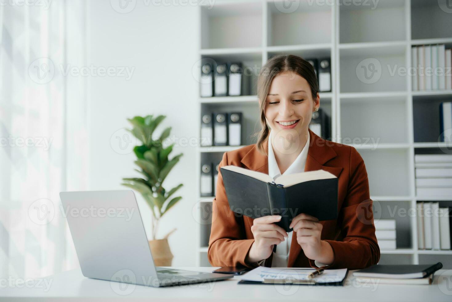 mujer leyendo libro mientras sentado a en hogar oficina foto
